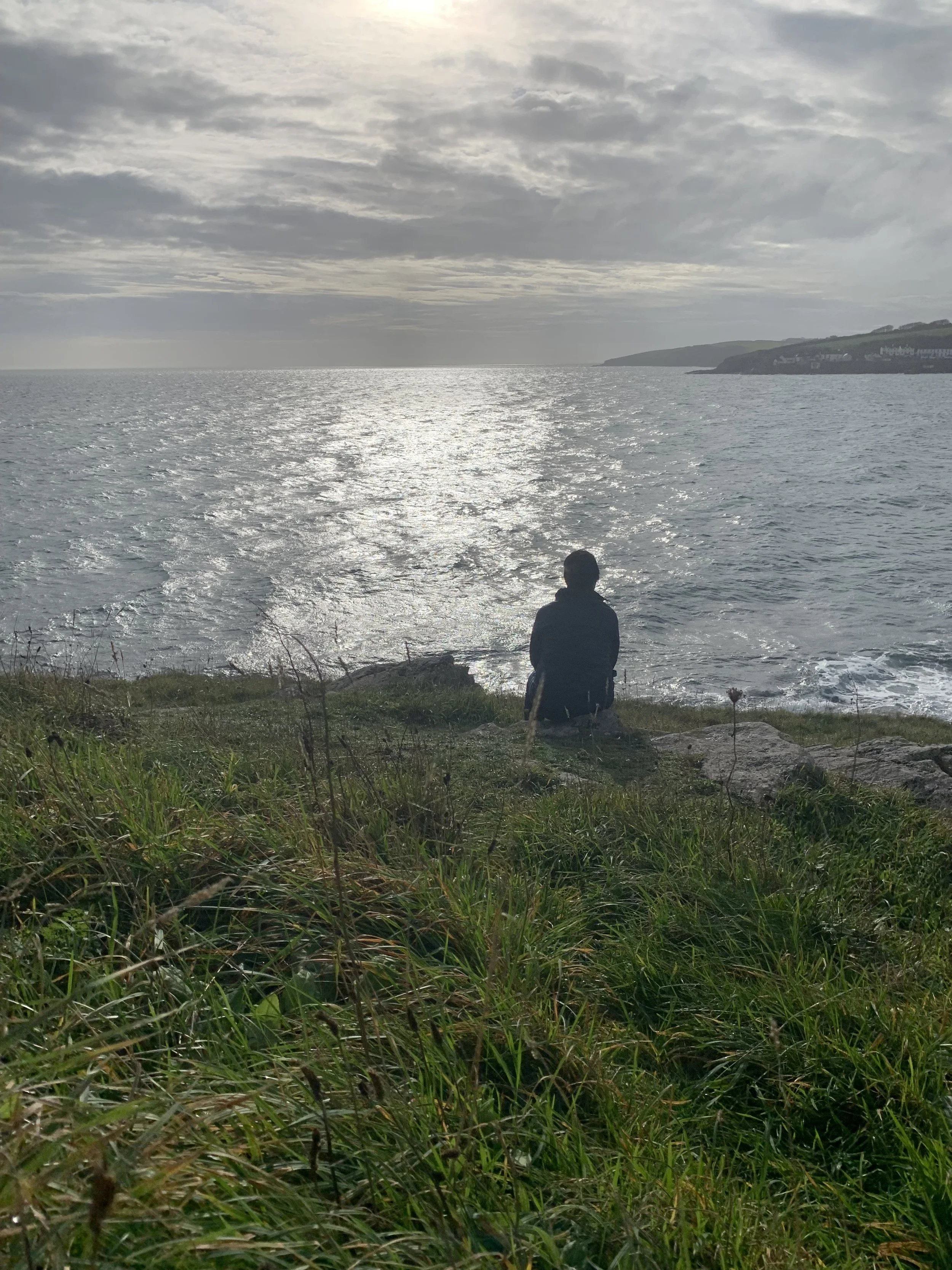 Nicky looking out to sea, embodying calm and quiet reflection