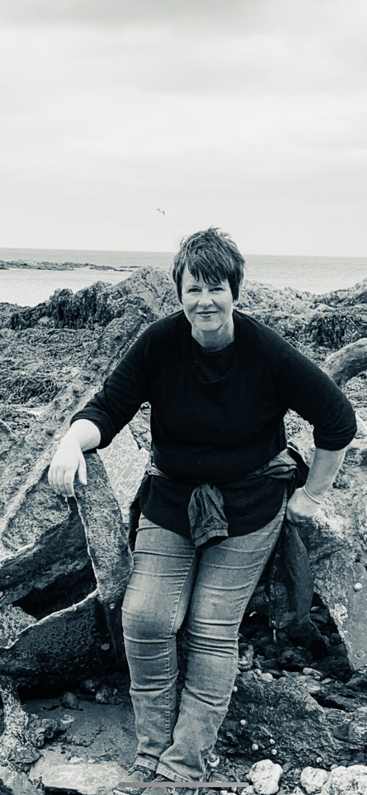 Nicky Osborne by the Cornish coast, embodying calm presence, wisdom, and grounded insight