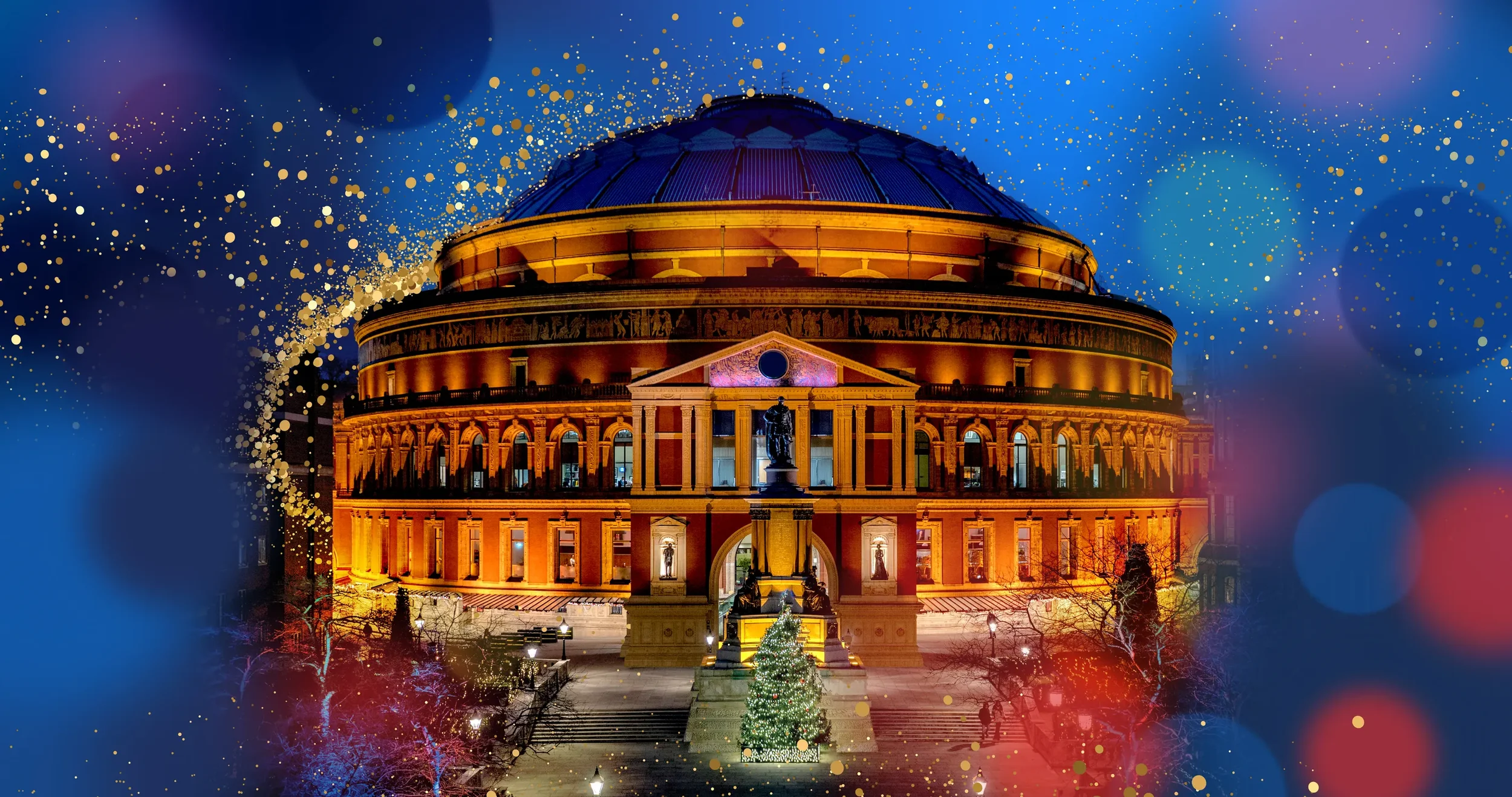 A large, historic building illuminated at night with a Christmas tree in front, decorated with lights, and surrounded by festive lights and bokeh effects.