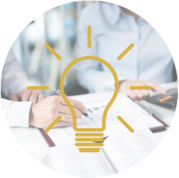 Person writing in a notebook with a digital tablet on the table, overlaid with a graphic lightbulb icon.