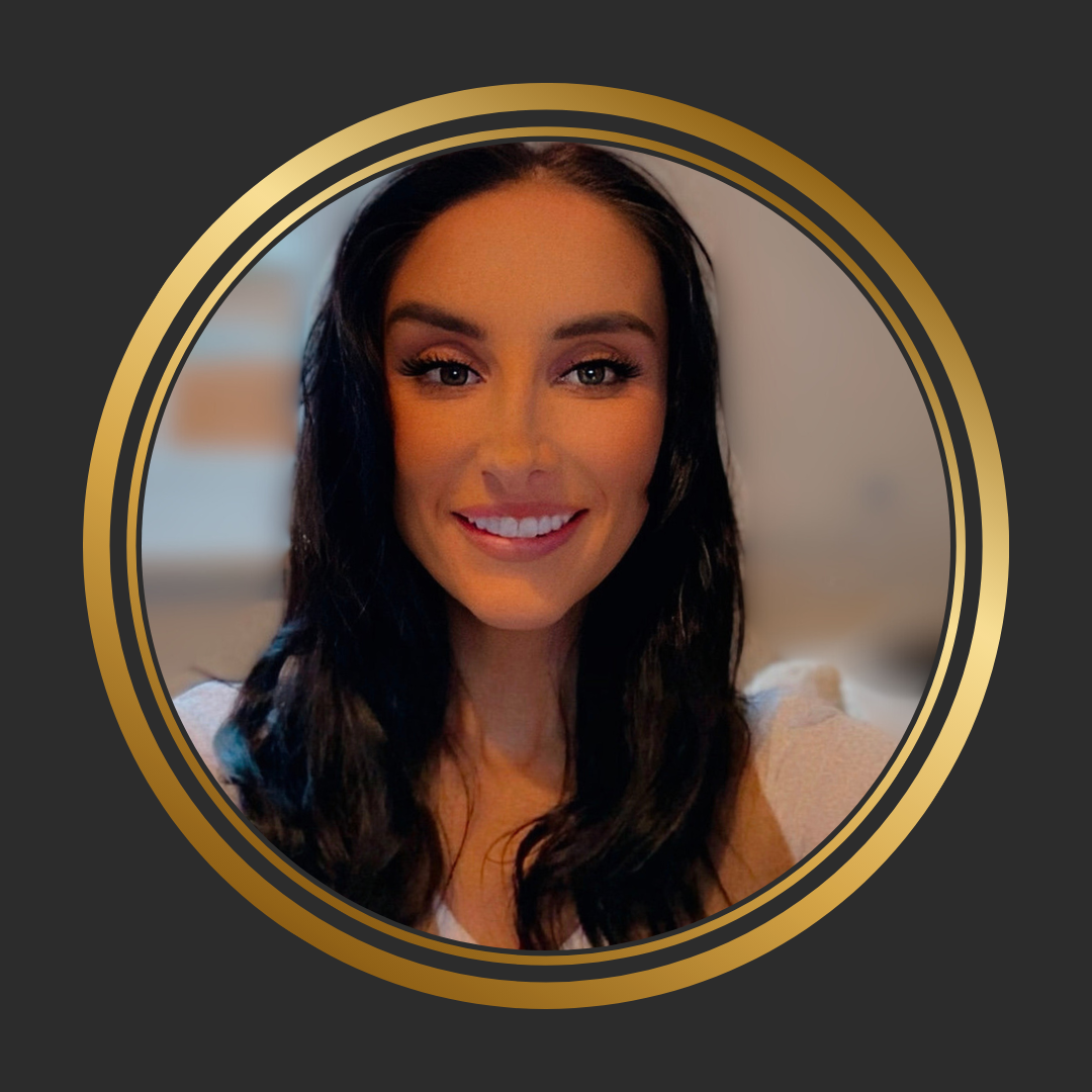 A smiling woman with long dark hair, wearing makeup and a light-colored top, looking directly at the camera, enclosed in a gold and black circular frame.