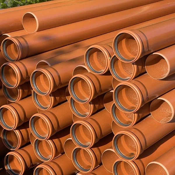 Stack of orange PVC pipes with open ends showing internal diameter.