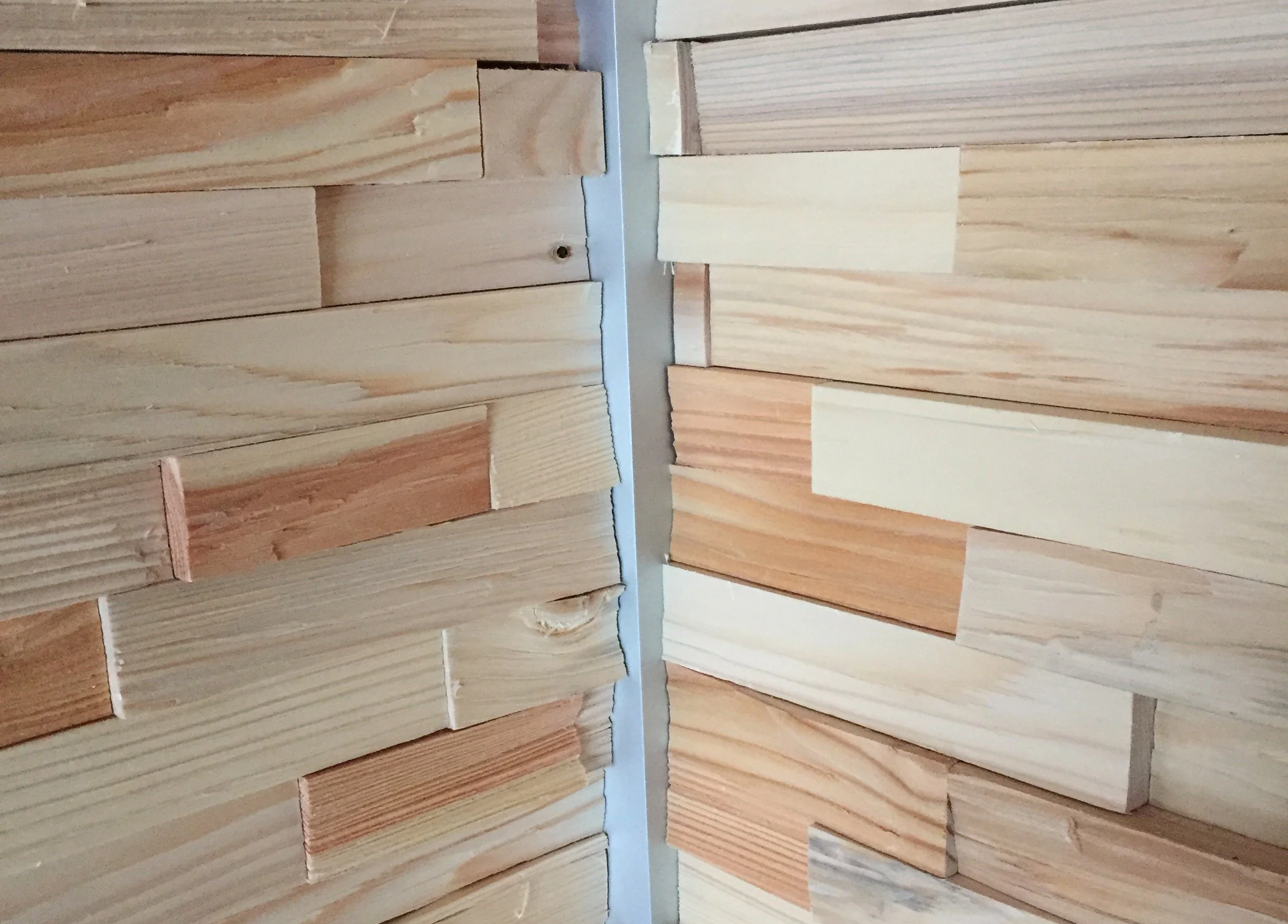 Détail du bois brut rénové et des textures naturelles dans un intérieur de chalet contemporain et chaleureux.