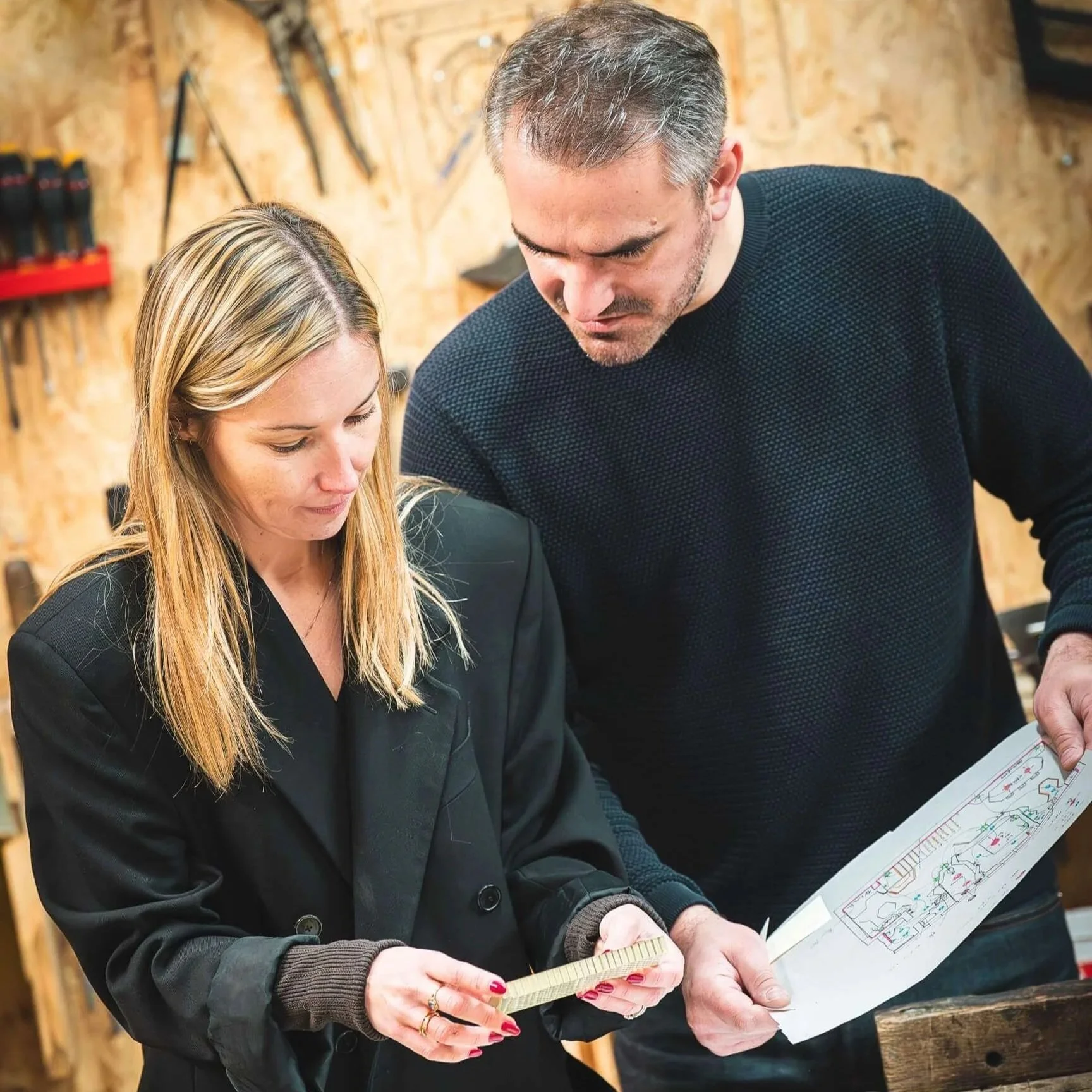 Anne et Jeremy, fondateurs d'Anjem Studio face à face, échangeant sur un projet ,dans leur atelier aux Rousses