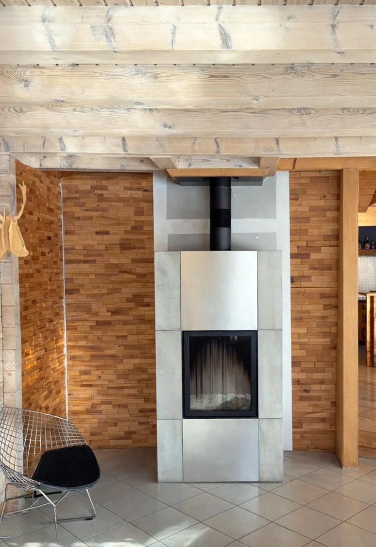 Autre angle du salon du chalet avec lumière douce, bois sublimé et lignes simples pour une atmosphère apaisante.