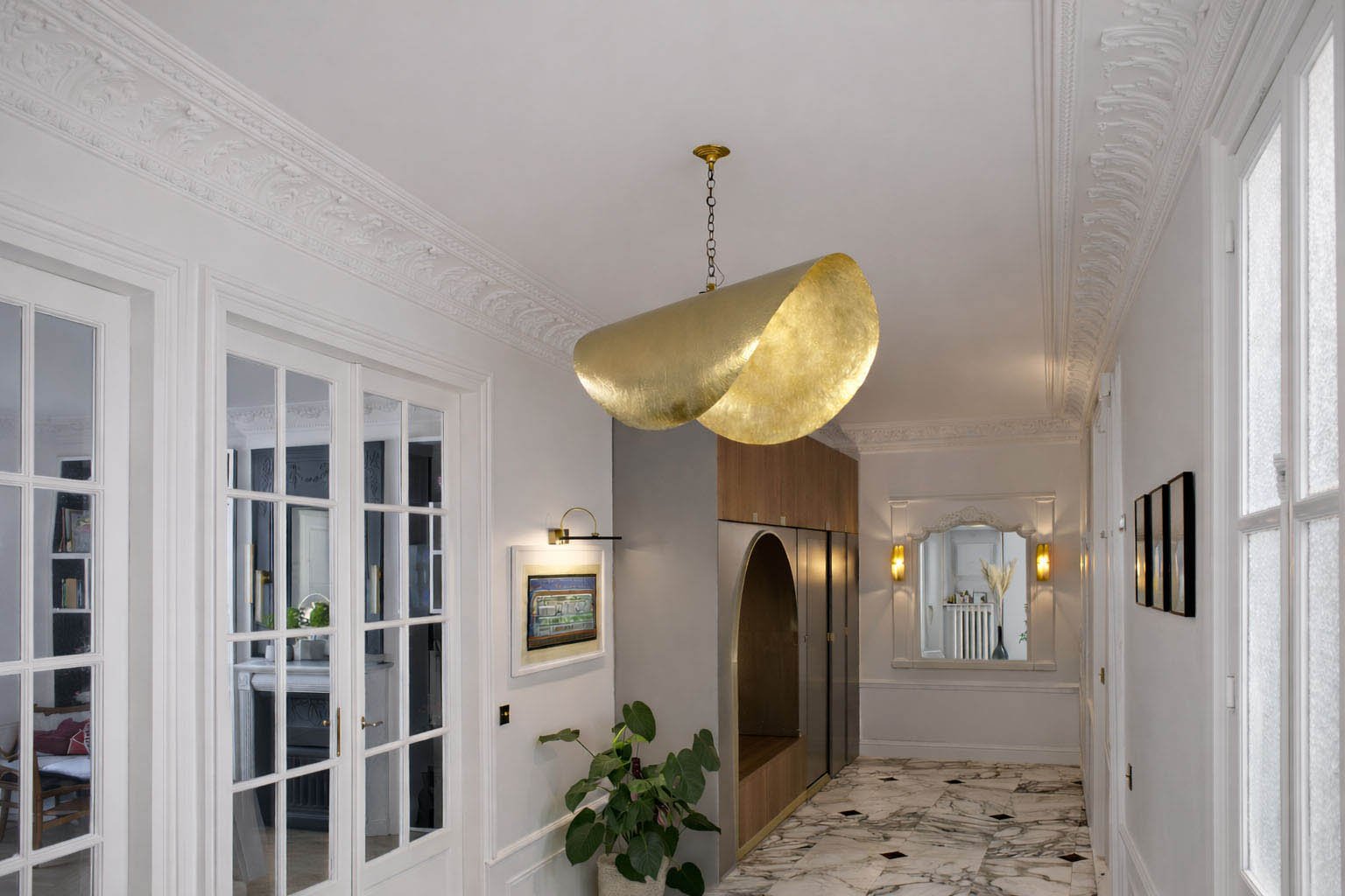 Perspective traversante d’un appartement parisien rénové, révélant la continuité des espaces et la lumière naturelle.