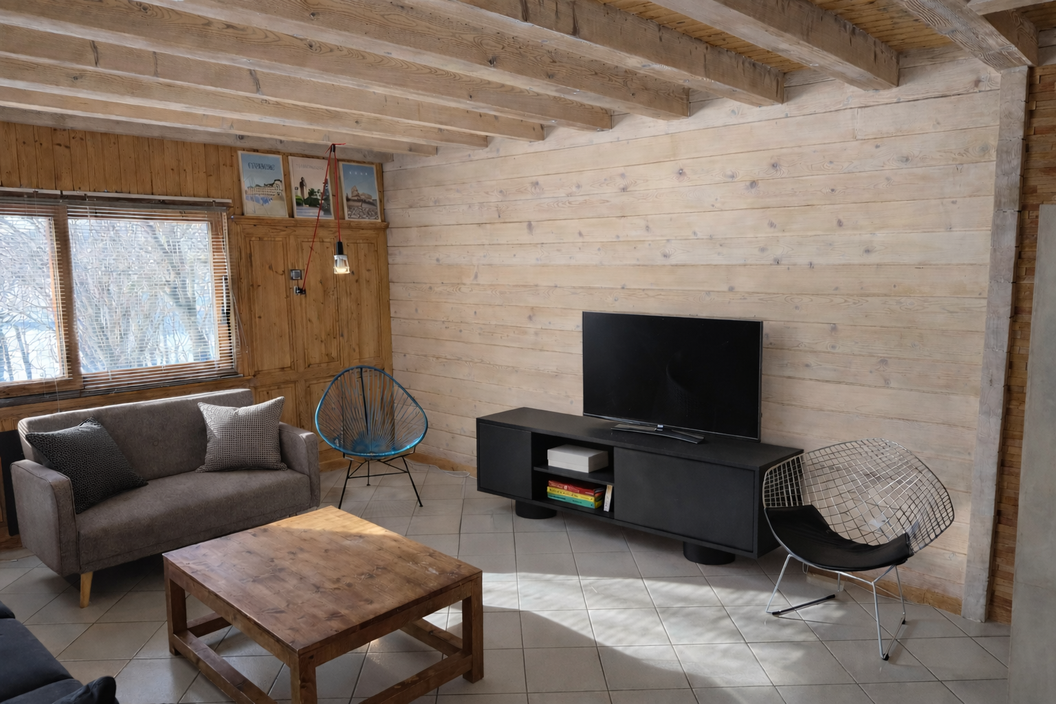 Vue d’un espace de vie en bois éclairé naturellement dans un chalet rénové, design montagne modernisé et harmonieux.