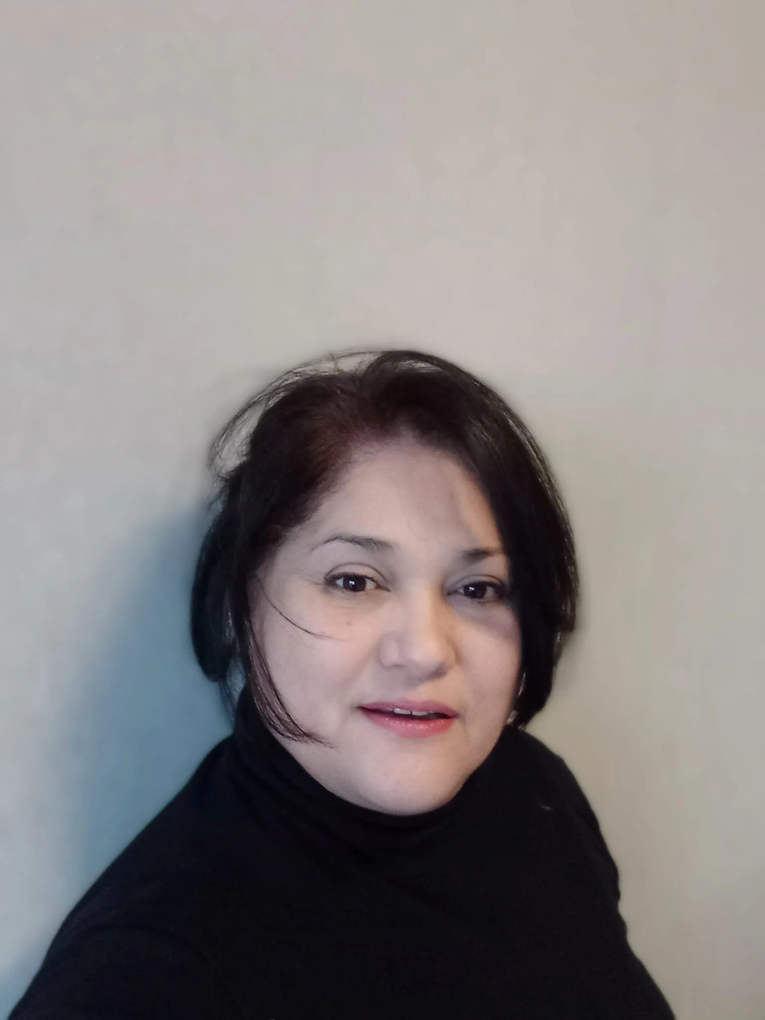 Portret van Edith Perez - Surrealist Artist
Portret van een vrouw met korte zwarte haar, lichte huidskleur, lichte make-up, zittend voor een effen lichte muur, gekleed in een zwart top.
