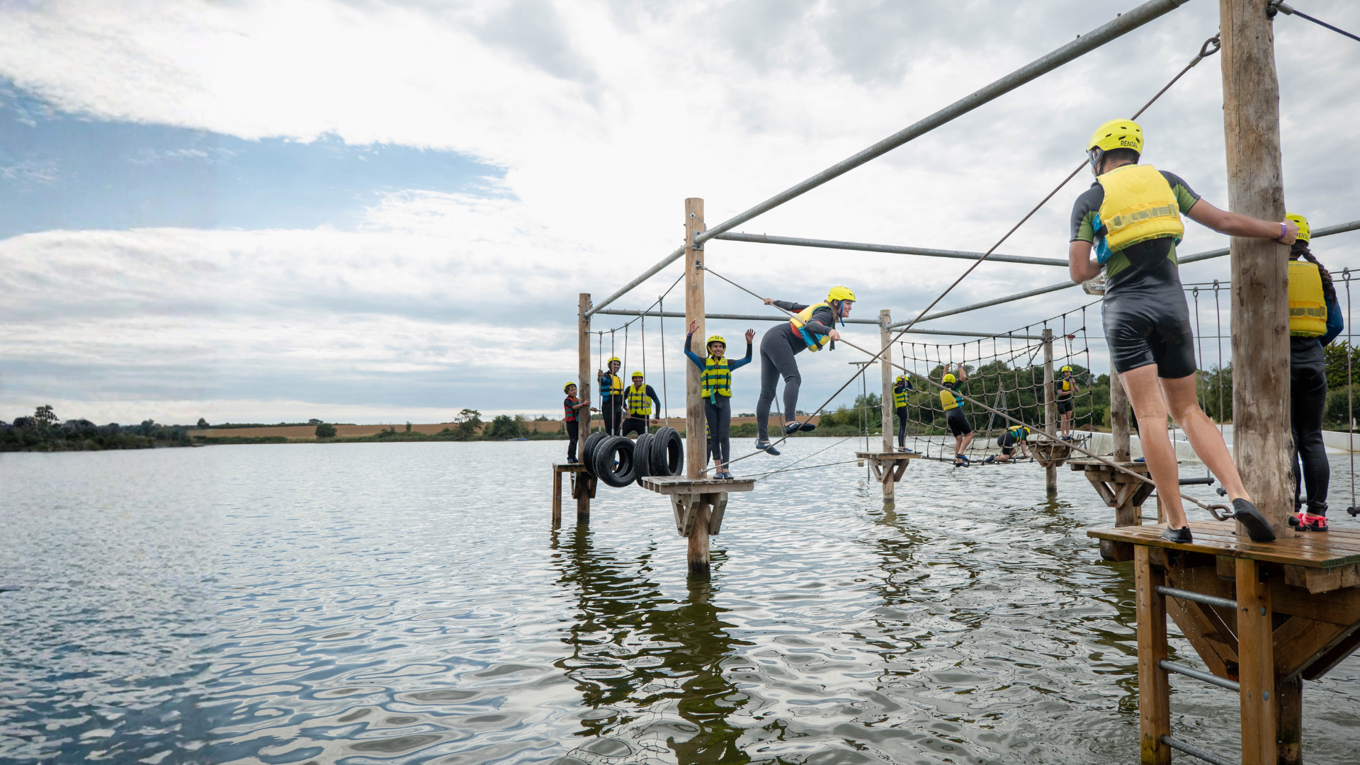 Families climbing the Aqua Climb at Curve Water Sports in Essex