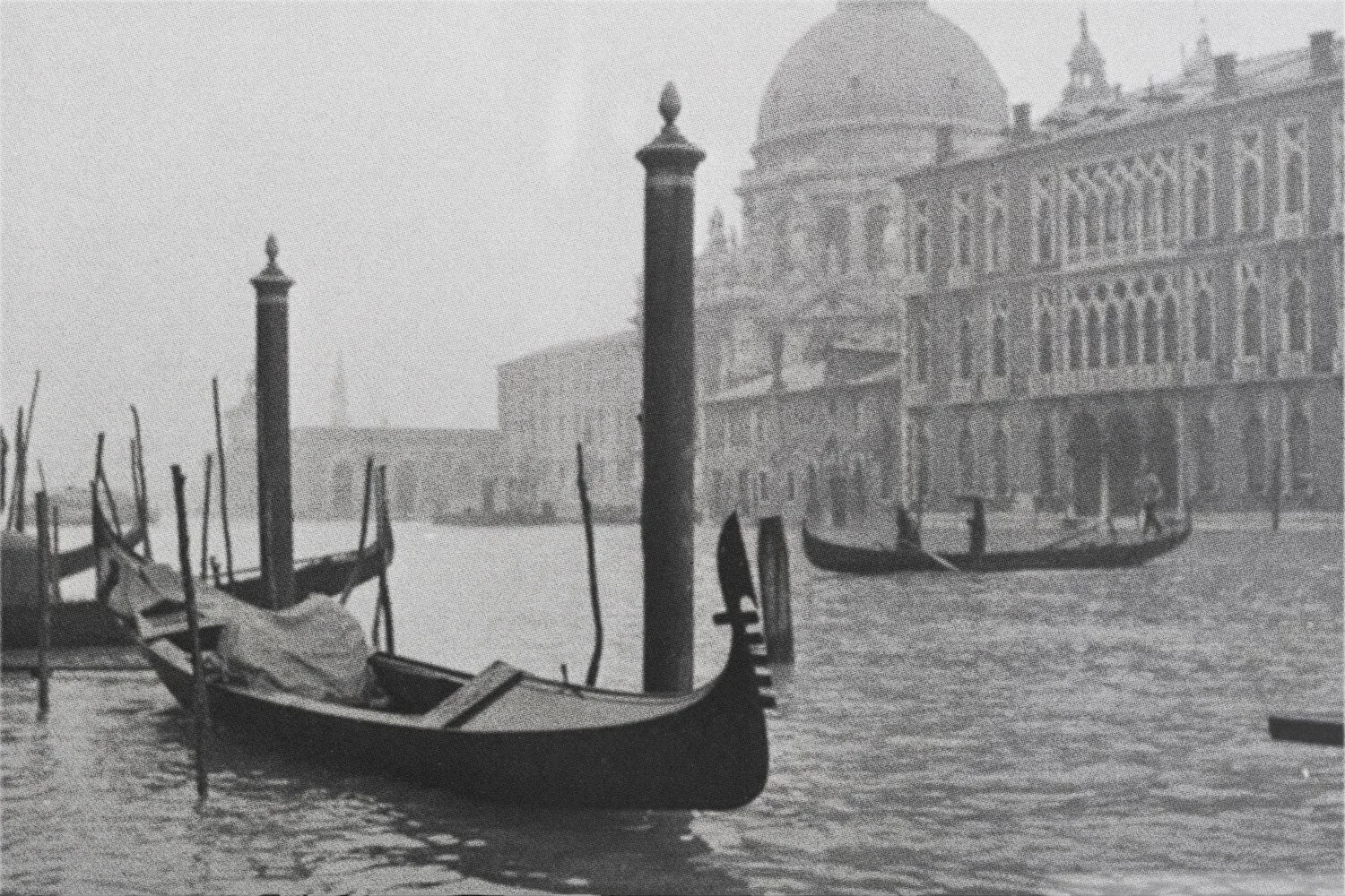 Deux gondoles voguant sur un canal à Venise, avec un bâtiment historique en arrière-plan.