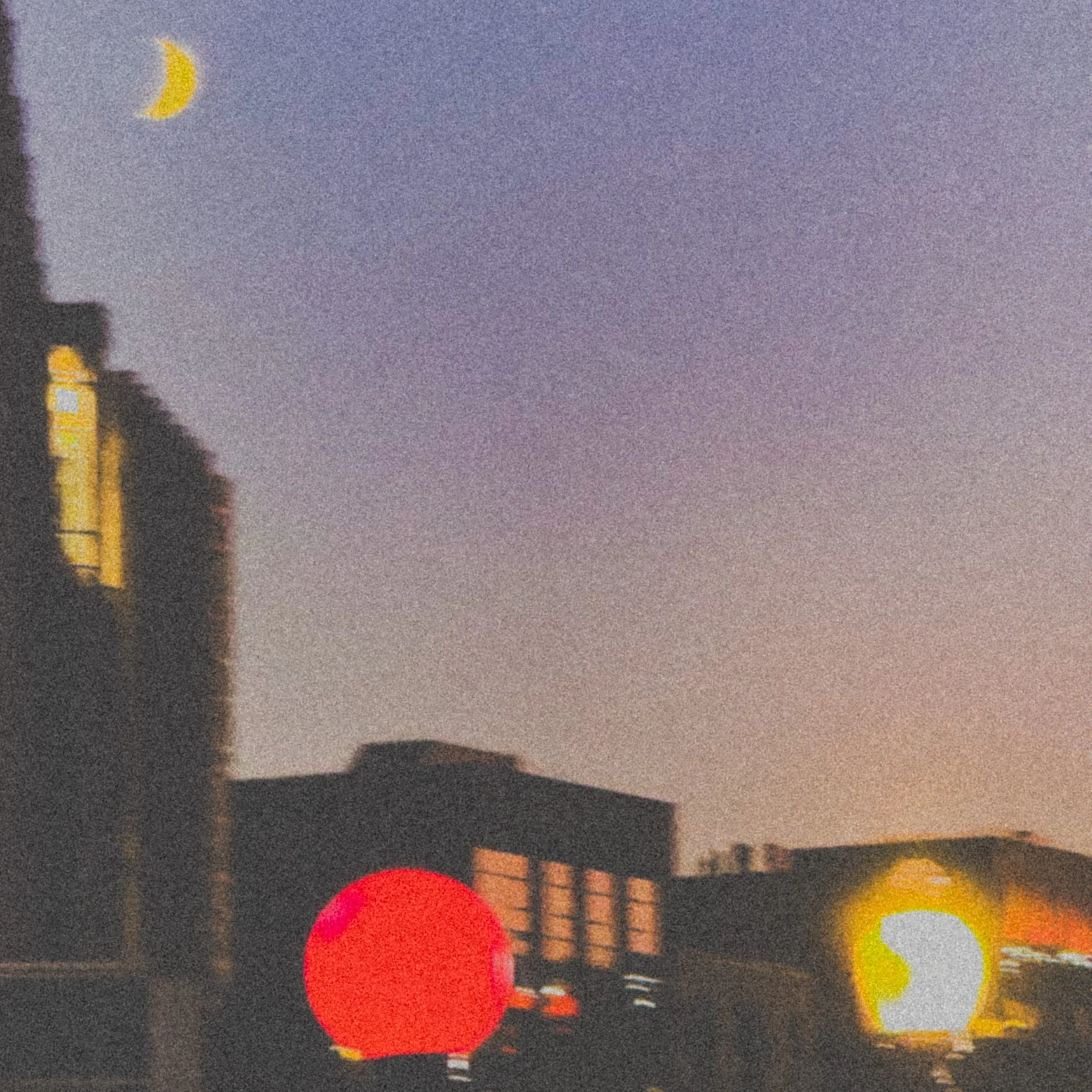 Cityscape at dusk with a crescent moon in the sky, featuring buildings and illuminated round lights in the foreground.