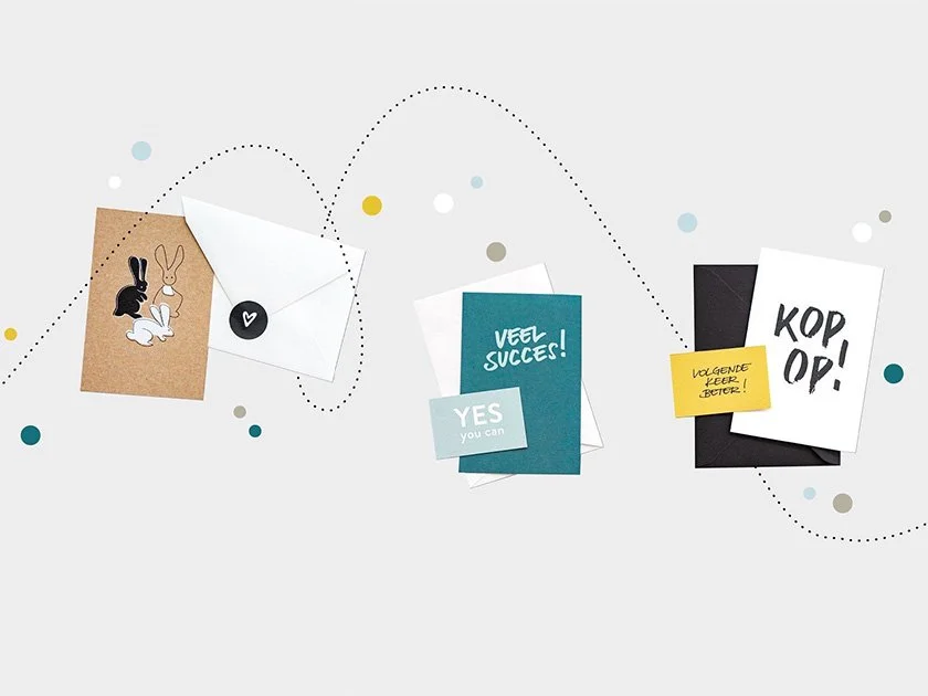 Collection of greeting cards, notes, and envelopes with motivational messages, along with illustrated stickers and colorful dots on a light background.