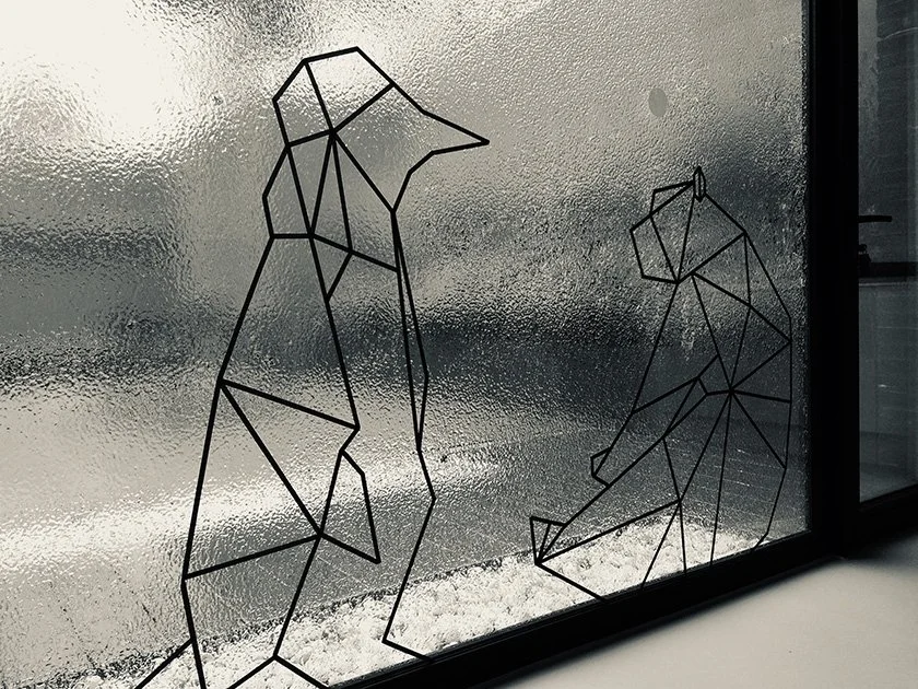 Line art of a bear and a wolf on a glass window.