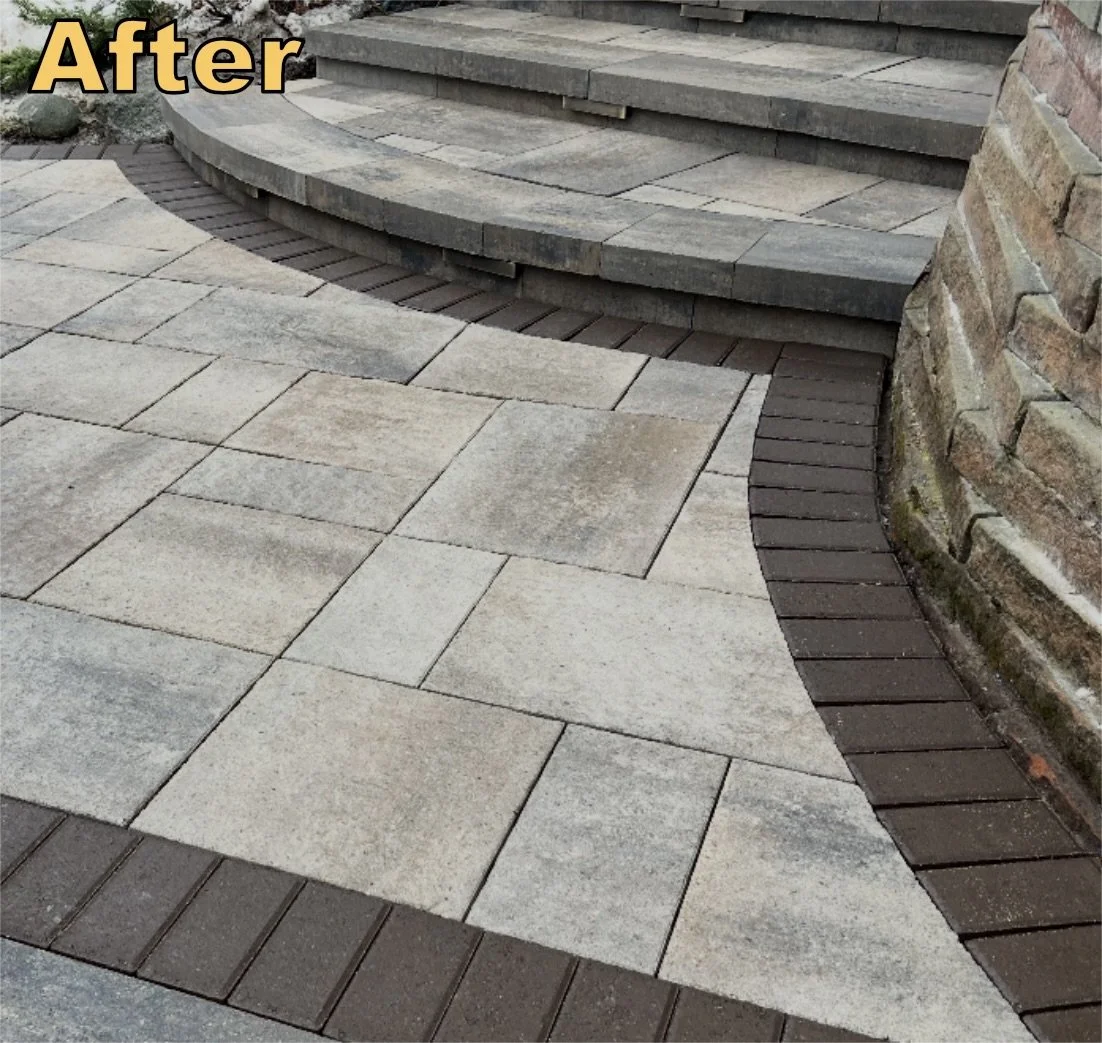 A recently renovated outdoor patio area with a combination of beige stone pavers and dark brown bricks, featuring curved steps and a brick wall.