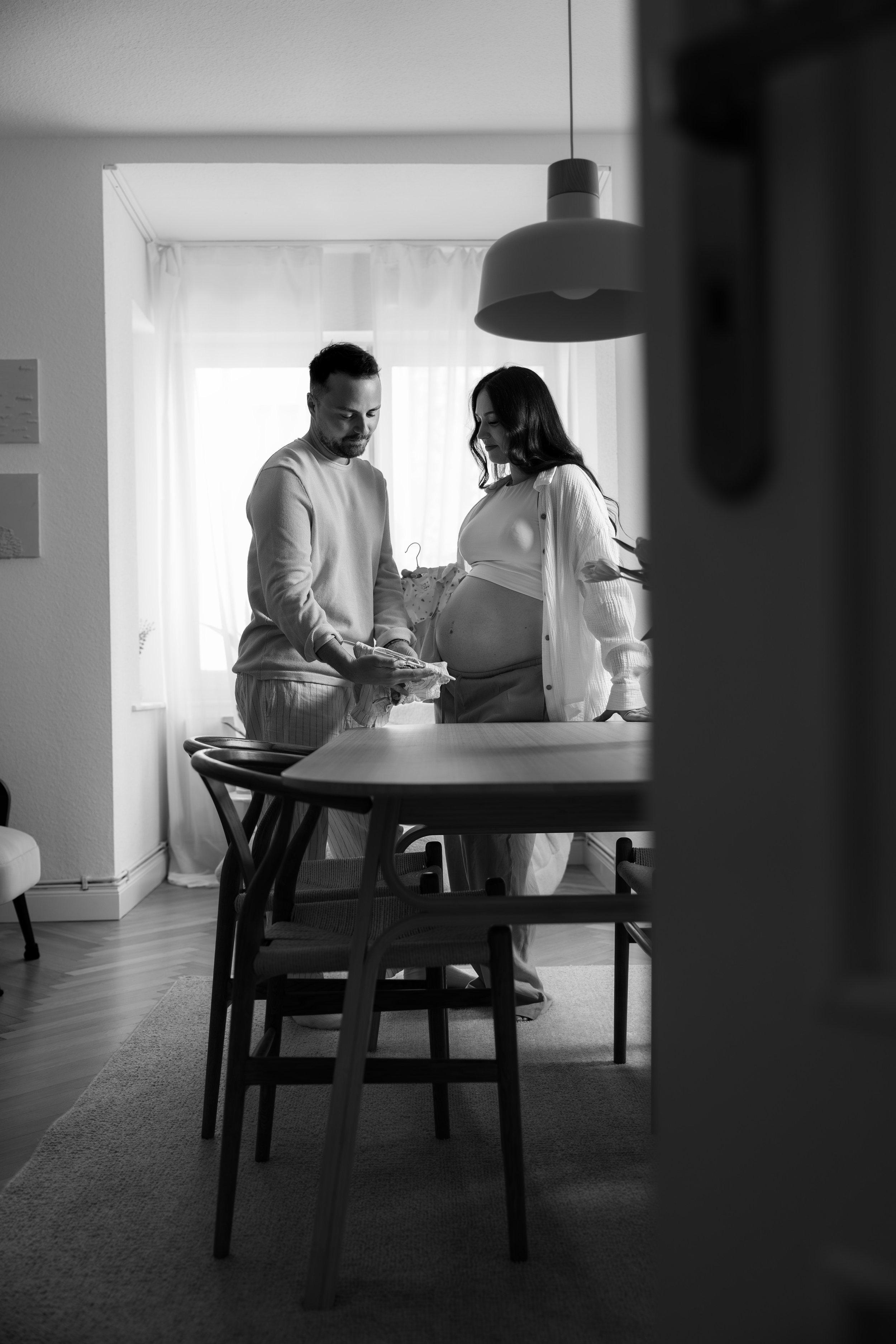 Authentische Babybauchfotografie in Hannover. Die werdenden Eltern verbringen einen ruhigen Moment zuhause und bereiten sich gemeinsam auf die Ankunft ihres Babys vor.