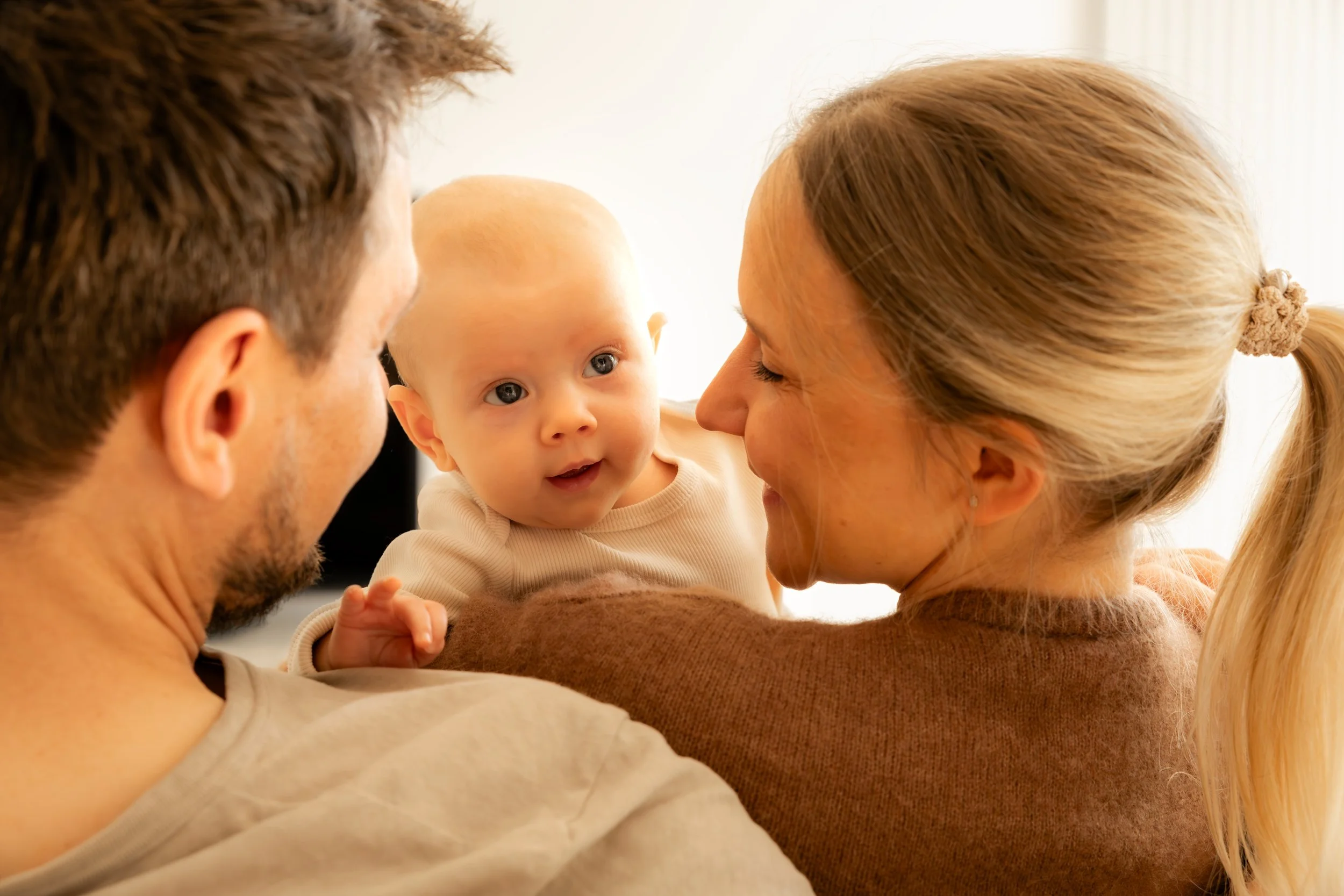 Eltern halten ihr Baby während eines natürlichen Familien- und Newbornshootings in Hannover im Arm.