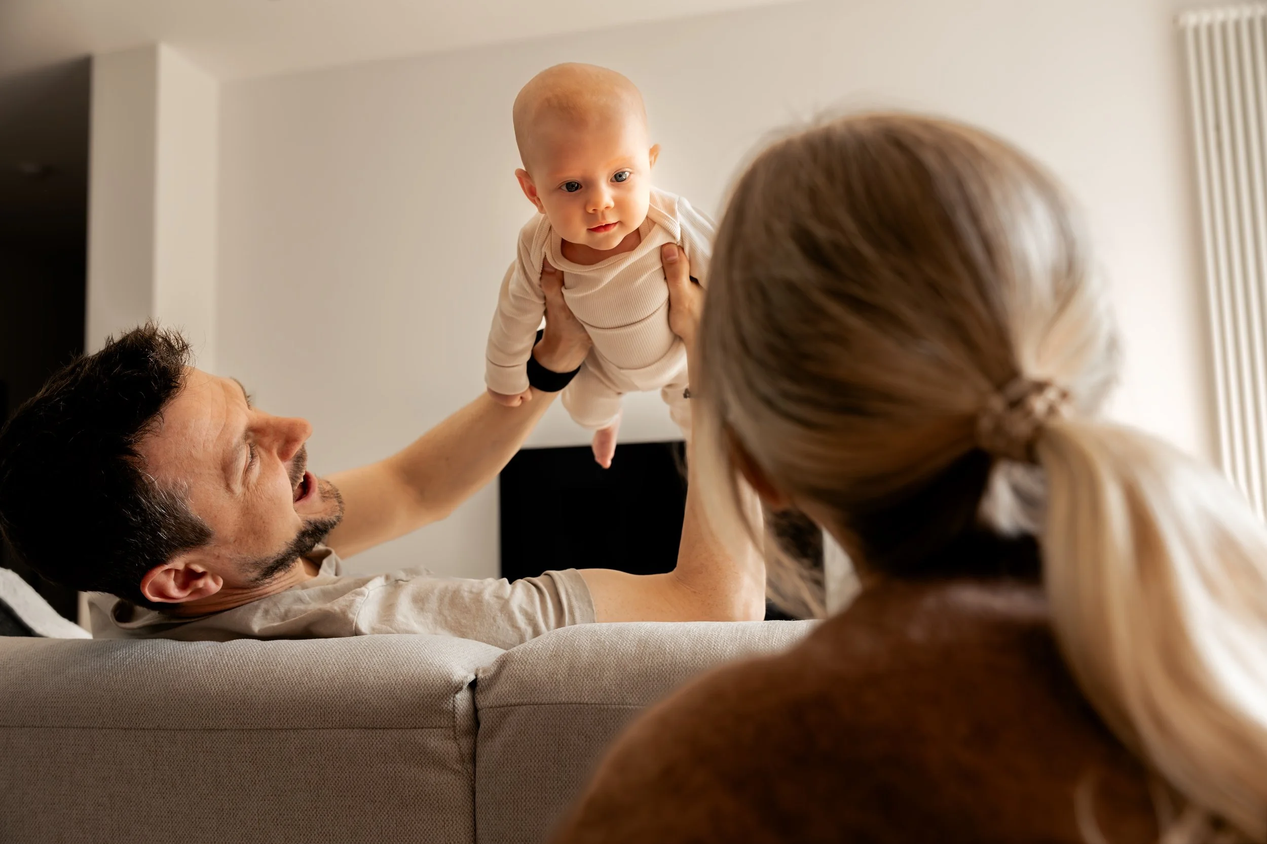 Eltern spielen während eines natürlichen Newbornshootings in Hannover mit ihrem Baby.