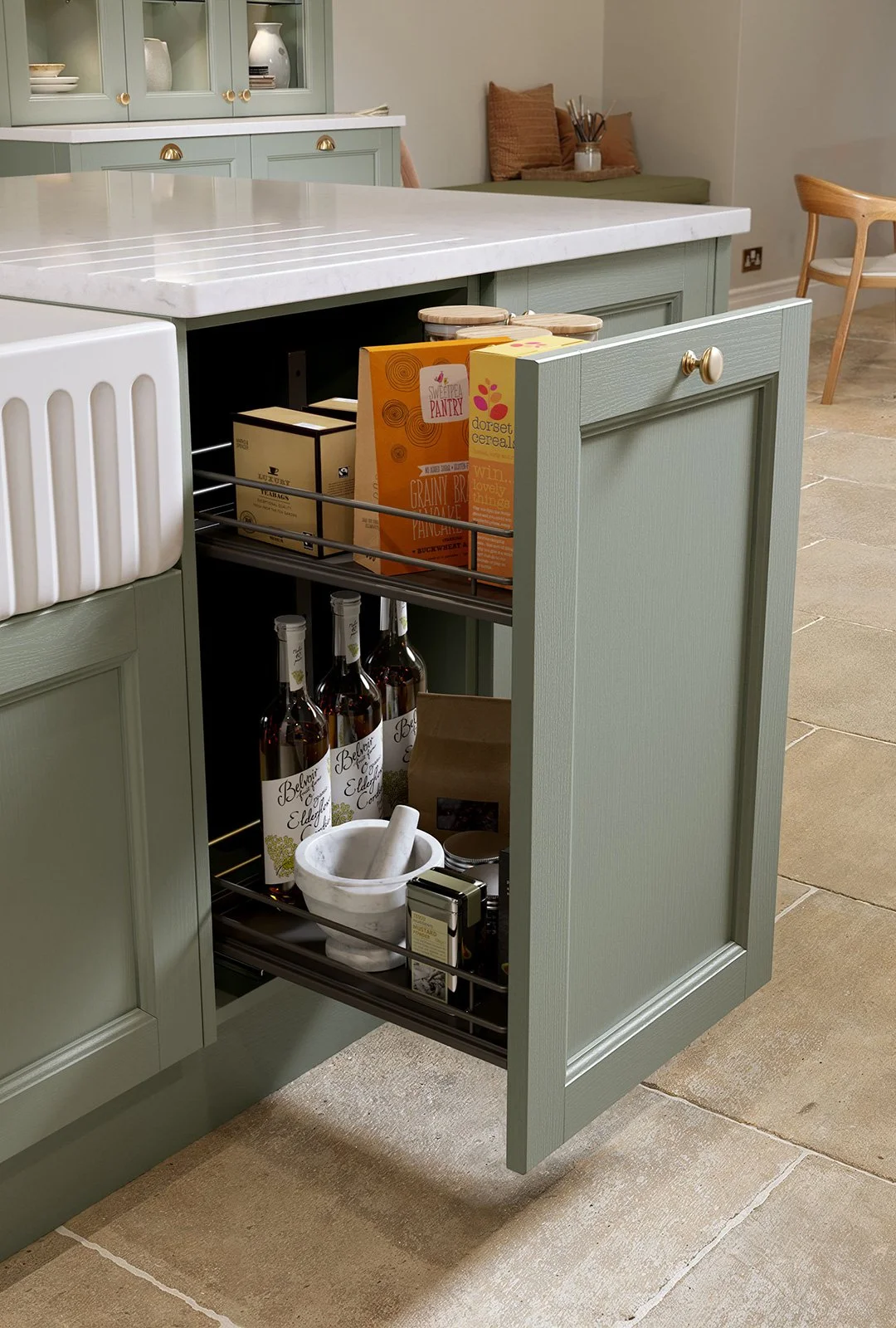 Open kitchen drawer with boxes of food, bottles, a mortar and pestle, and other kitchen items inside.