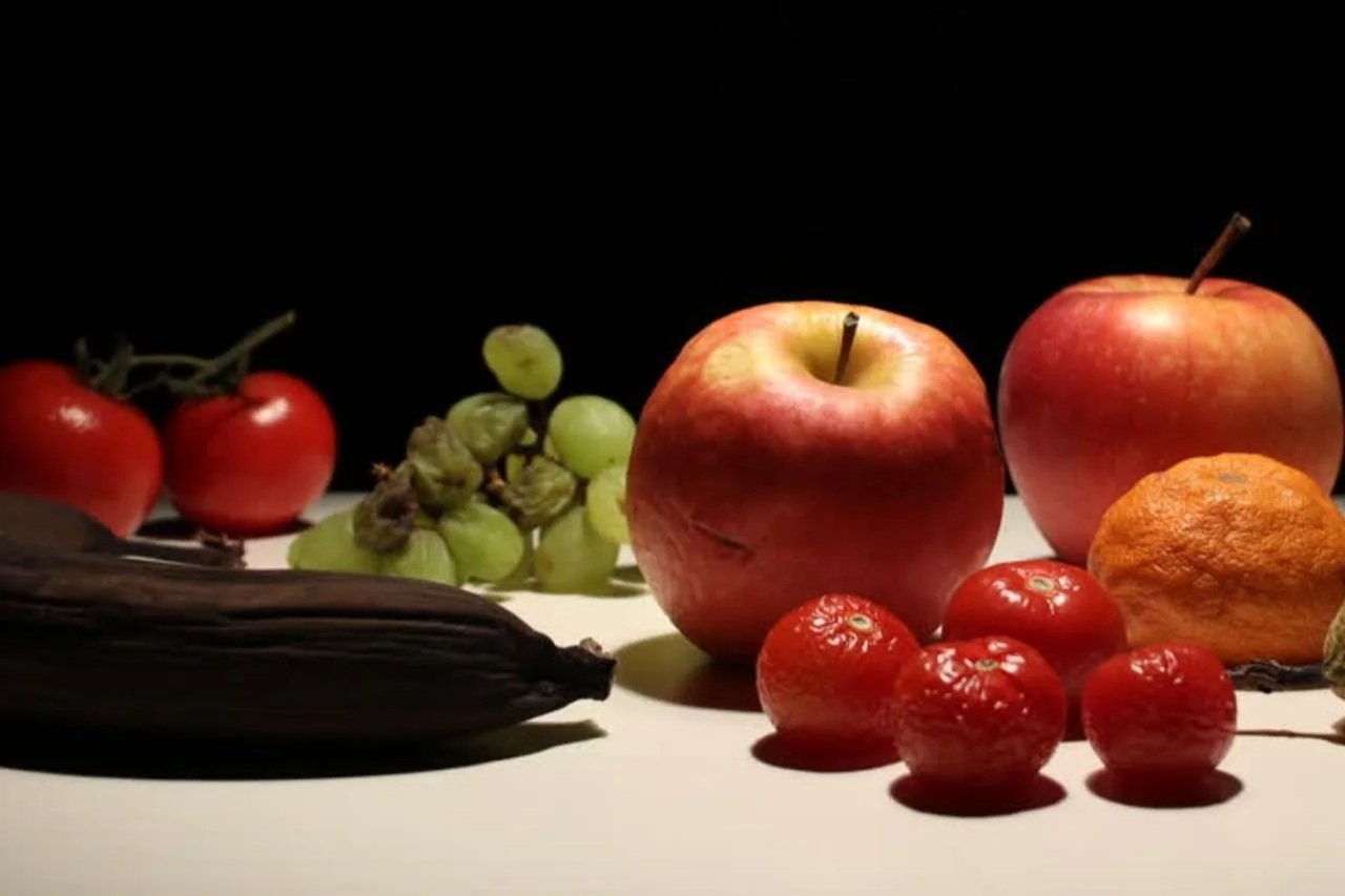 Timelapse de fruits pourrissant autour d'une pomme saine : métaphore de la sur-adaptation dans un environnement toxique.