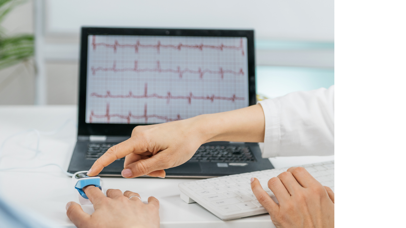 Une personne ajuste un moniteur de fréquence cardiaque, avec un graphique d'ECG à l'écran, dans le cadre d'une consultation en biofeedback.