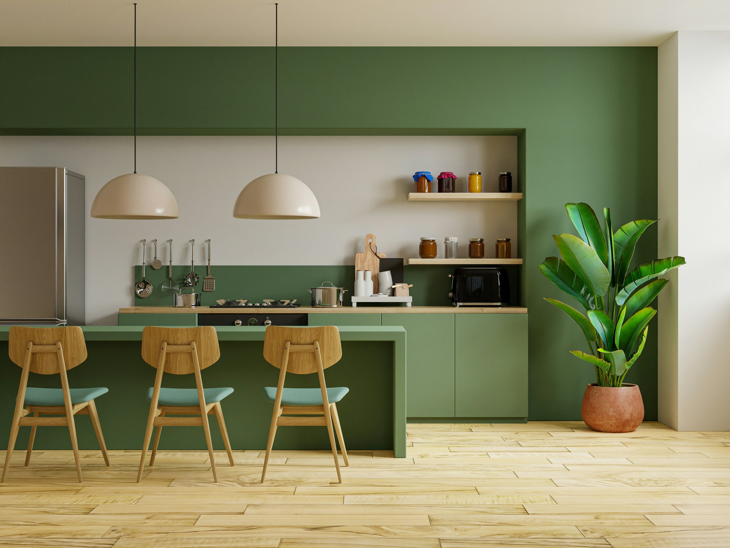 Modern kitchen with green cabinets, a wooden island with three chairs, hanging white pendant lights, open shelves with jars, a large potted plant, and a wooden floor.