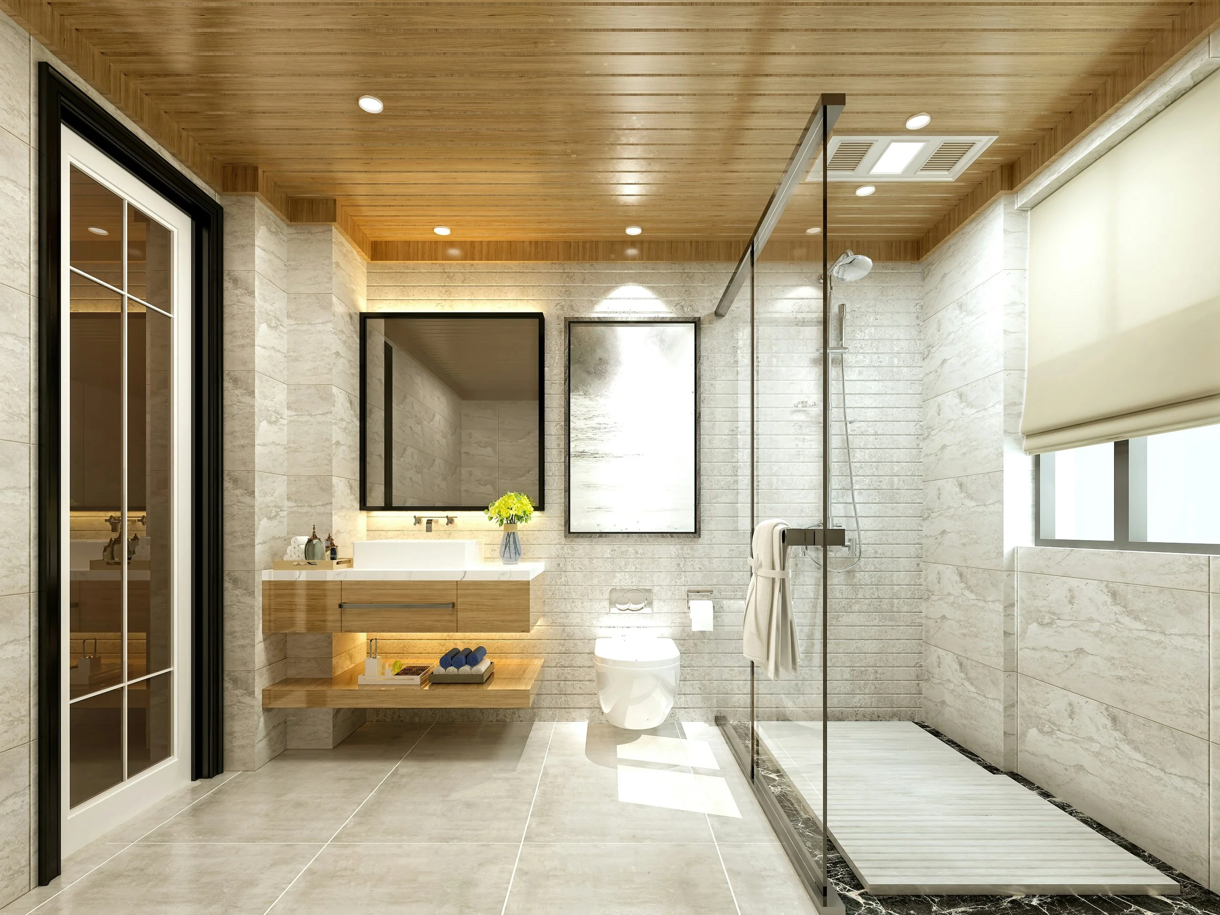 Modern bathroom with wooden ceiling, tiled walls, a glass-enclosed shower, a floating wooden vanity with a mirror, a vase of green flowers, a toilet, a window with a roller shade, and sliding glass doors.