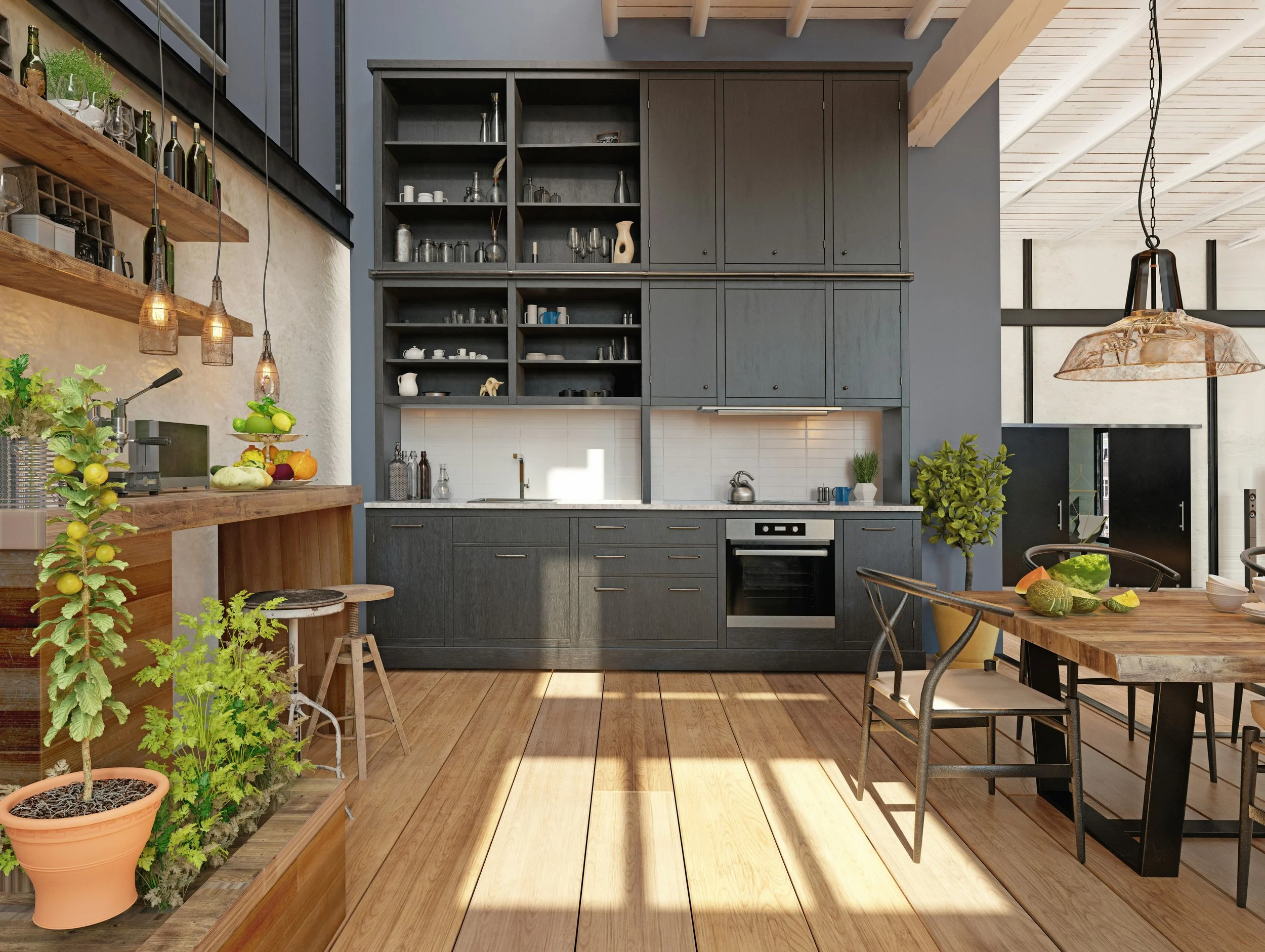 A modern kitchen with dark lower cabinets and open upper shelves, a wooden table with chairs, green plants, and a pendant lamp, with sunlight streaming onto wooden flooring.
