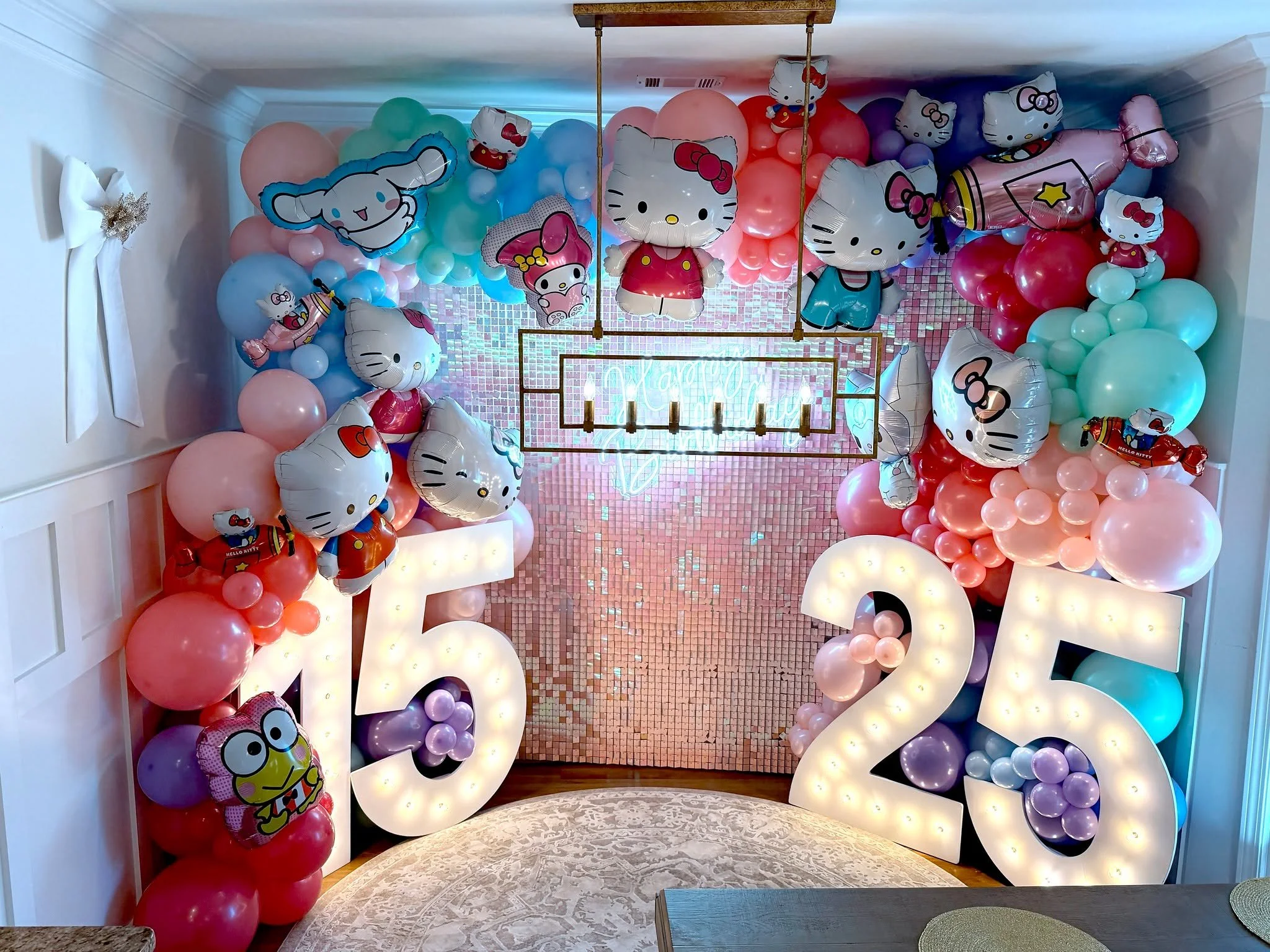 Birthday celebration for a 15-year-old and 25-year-old, styled in a dreamy Hello Kitty theme! 🎀🎉 The celebration was beautifully decorated with Hello Kitty&ndash;themed balloon d&eacute;cor, a dreamy pink shimmer wall, 4-foot marquee numbers, a flo