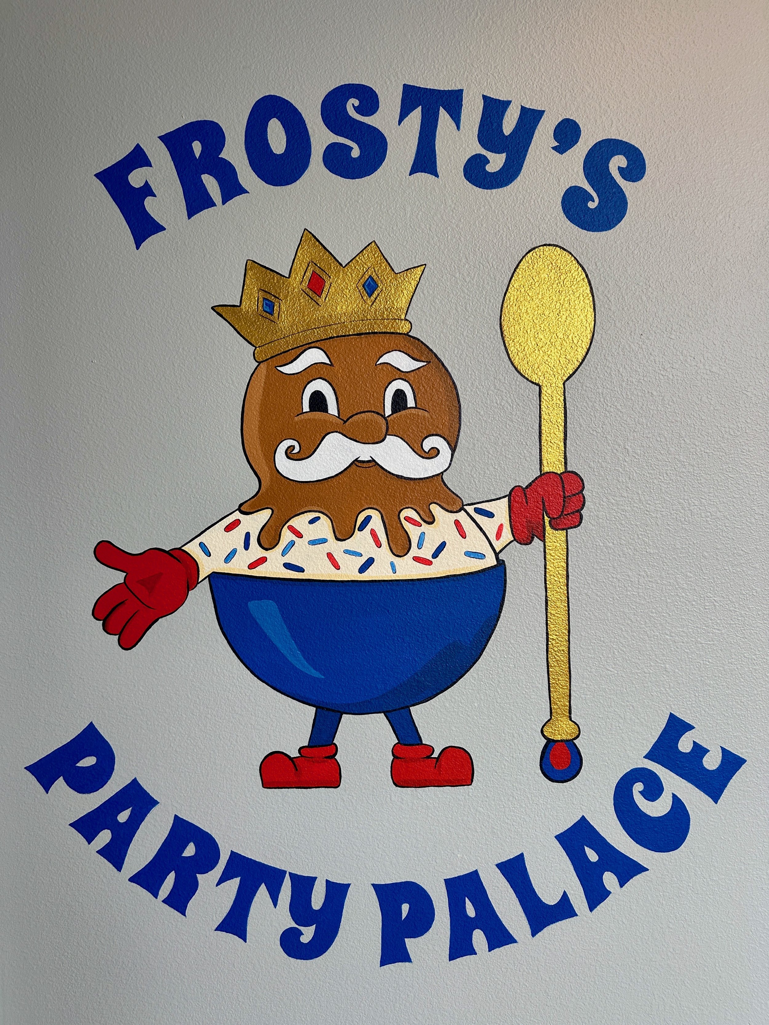 A cartoon character with a brown pudding-like body, white mustache, and eyebrows, wearing a golden crown, red gloves, red shoes, and a white shirt with colorful sprinkles, holding a yellow spoon in one hand. The text reads 'Frosty's Party Palace'.