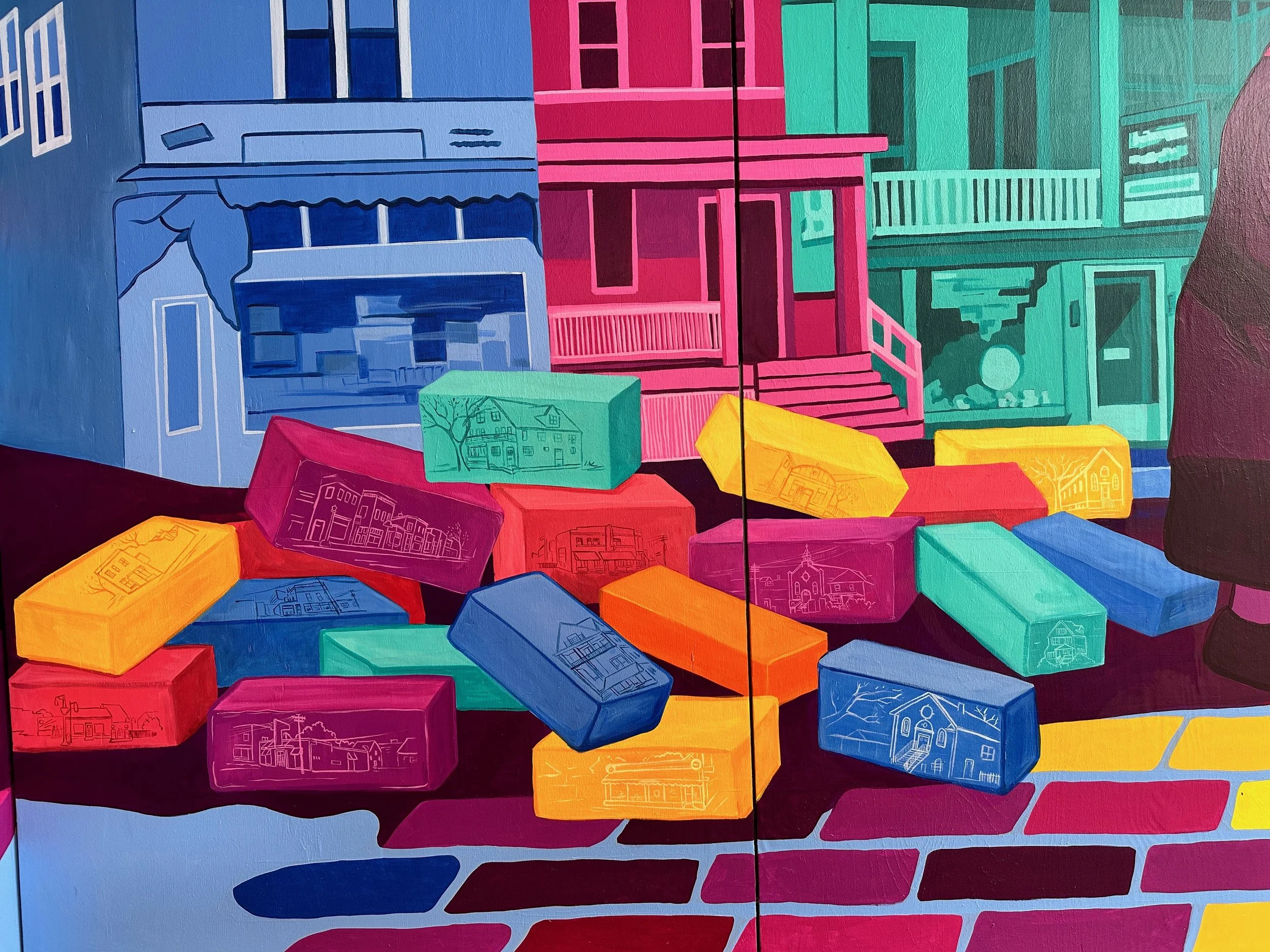 Colorful mural depicting a cityscape with buildings, stairs, and scattered bricks in vibrant colors including pink, blue, green, yellow, and red.
