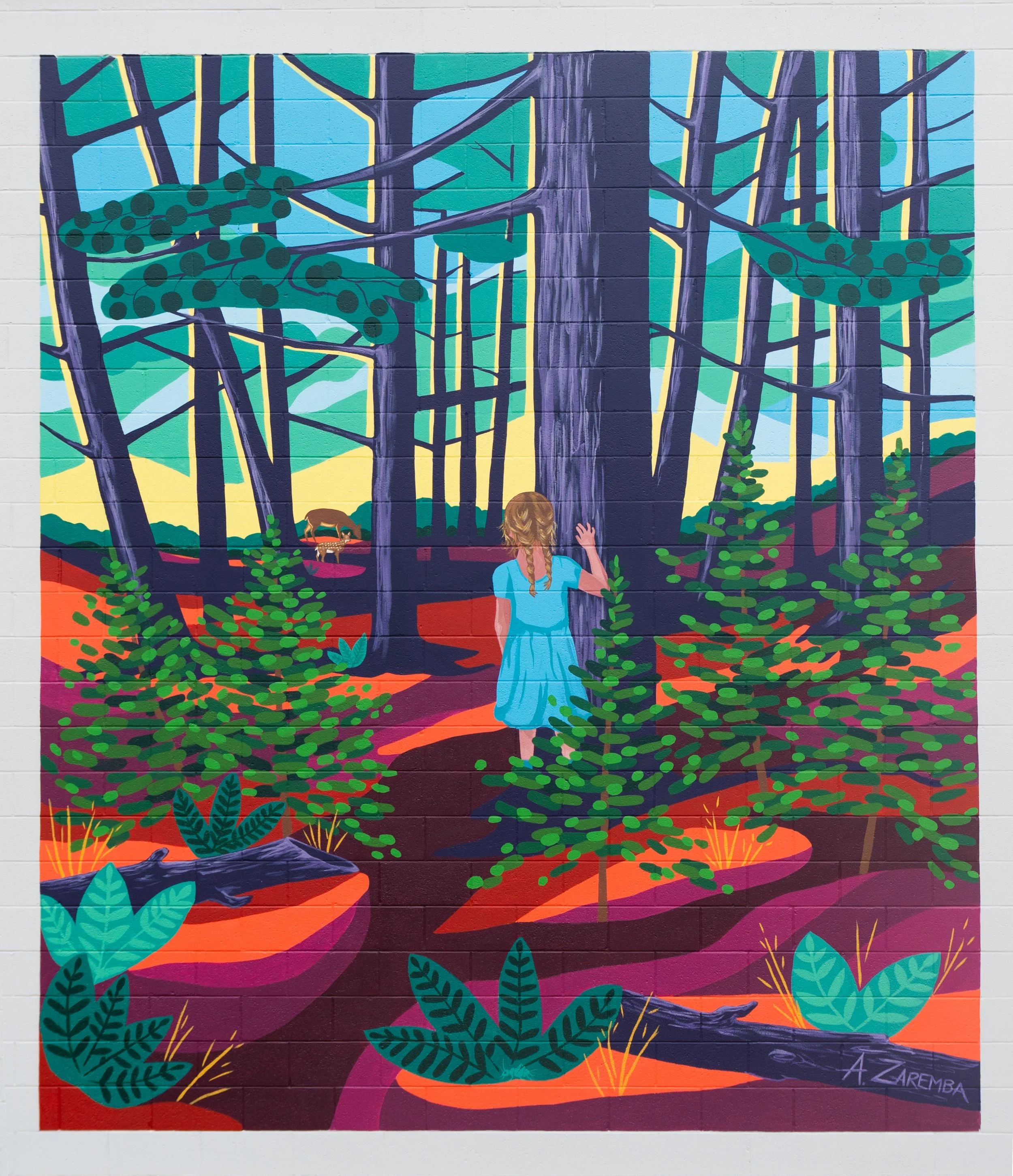 A colorful mural depicting a girl in a blue dress standing in a forest, reaching out to a large tree. The scene includes green trees and bushes, with a cow grazing in the background and a vibrant sunset sky.