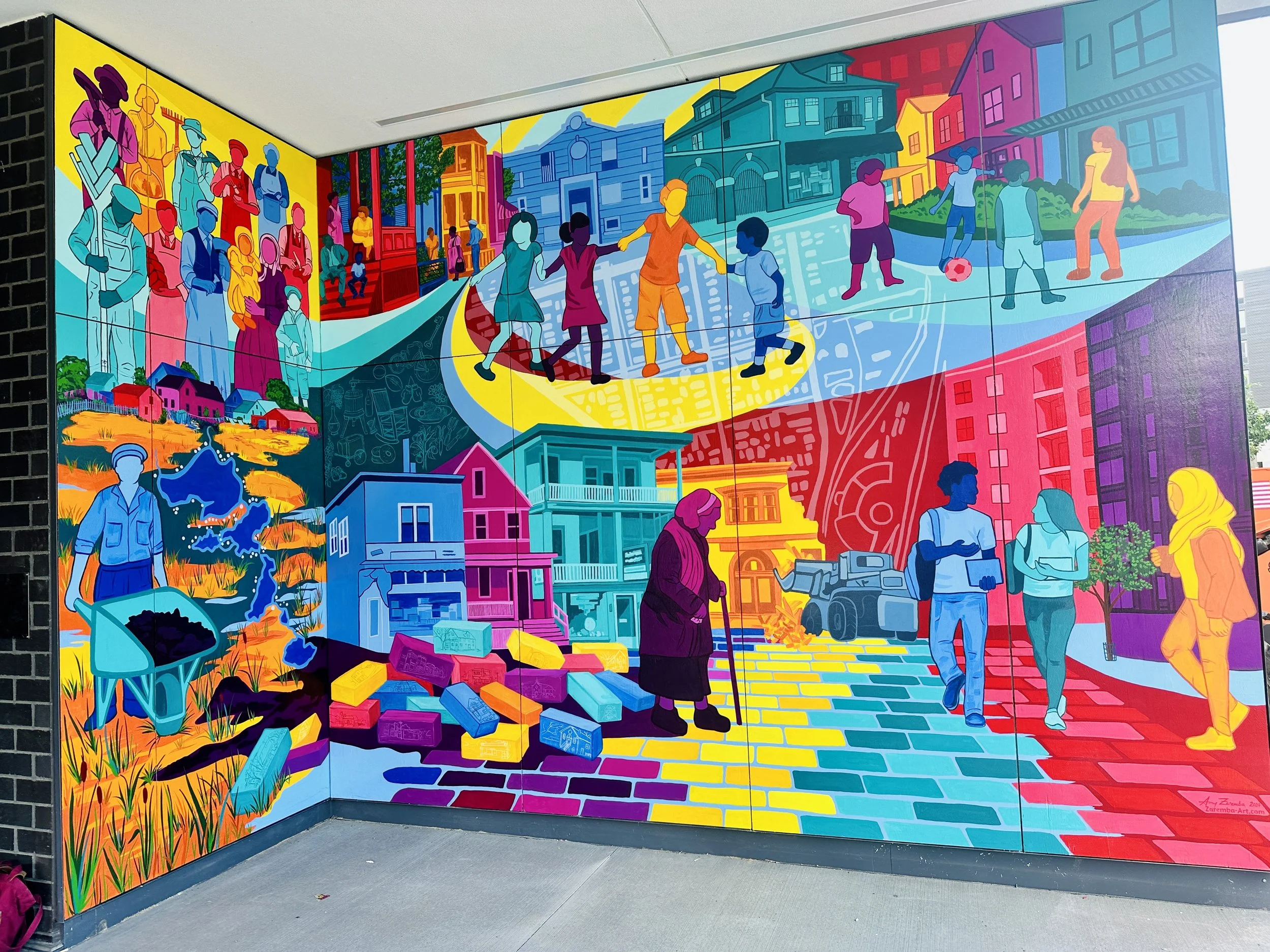 Colorful mural depicting diverse scenes of community life, including children playing, people walking, and working in fields, with vibrant buildings and neighborhoods in the background.