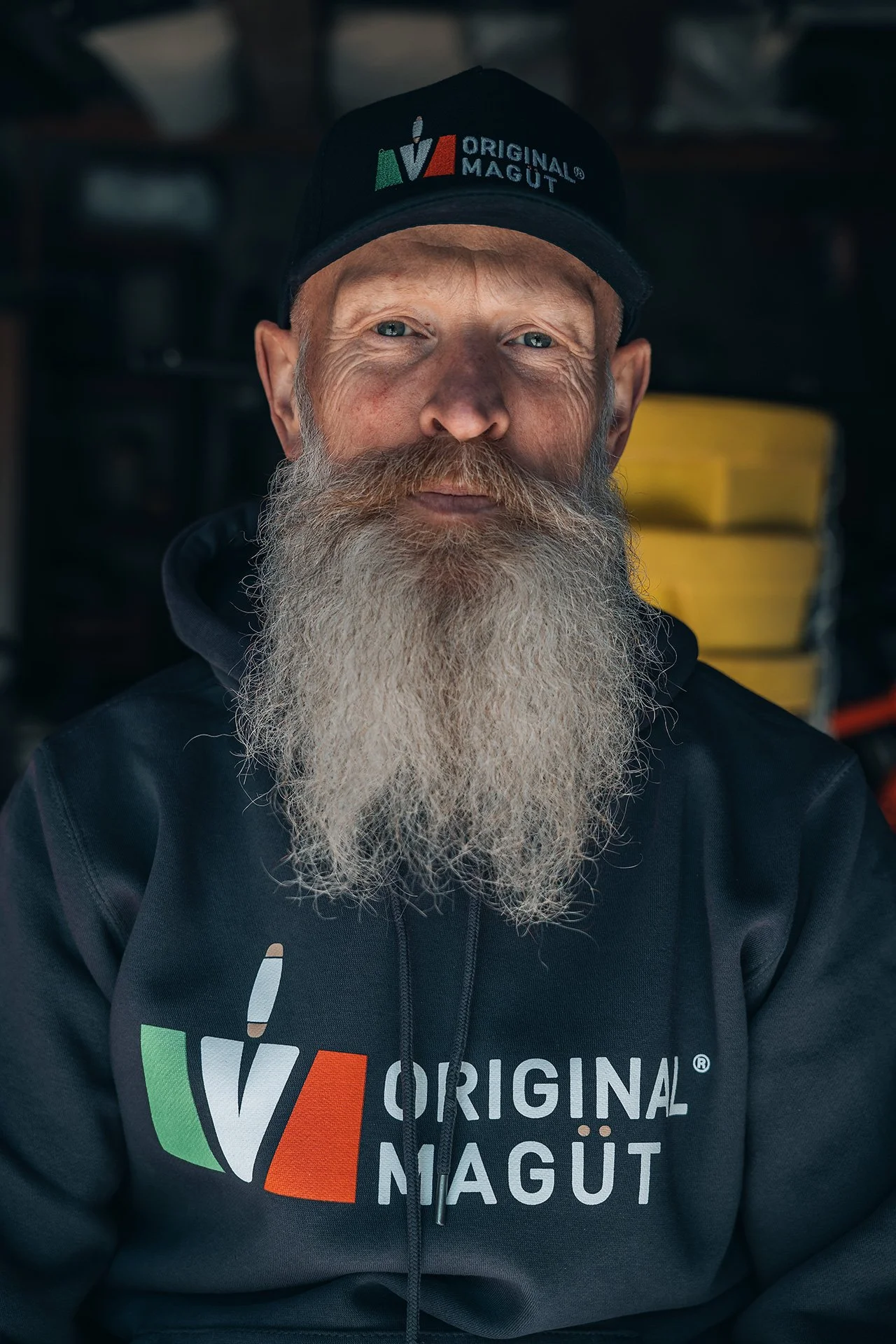 Uomo con barba lunga e cappello nero che indossa una felpa con logo dell'Oktoberfest originale della Baviera.