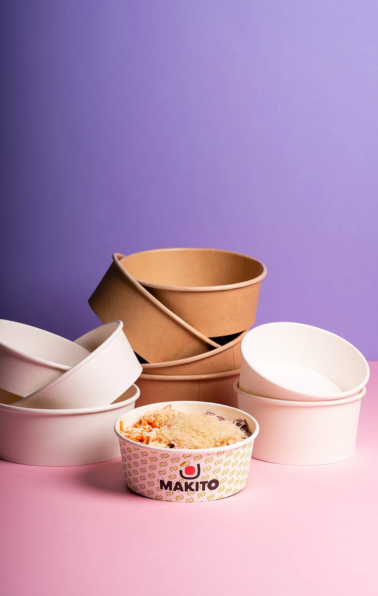 Vasetti di plastica vuoti e uno con pizza, sfondo rosa e viola.