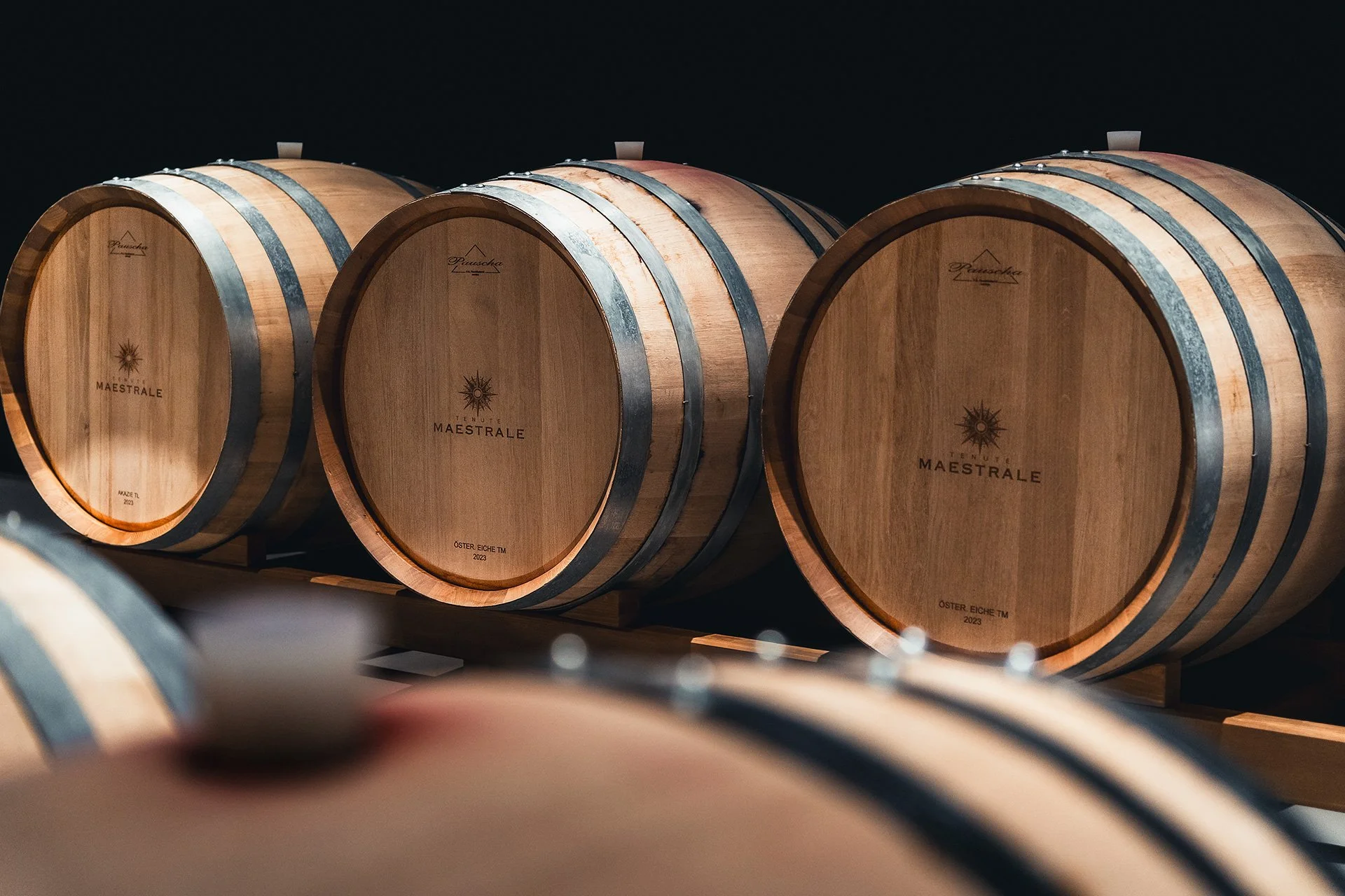 Barili di vino in una cantina, con un'etichetta che indica Maestrale, ottO Eiche, e l'anno 2023.