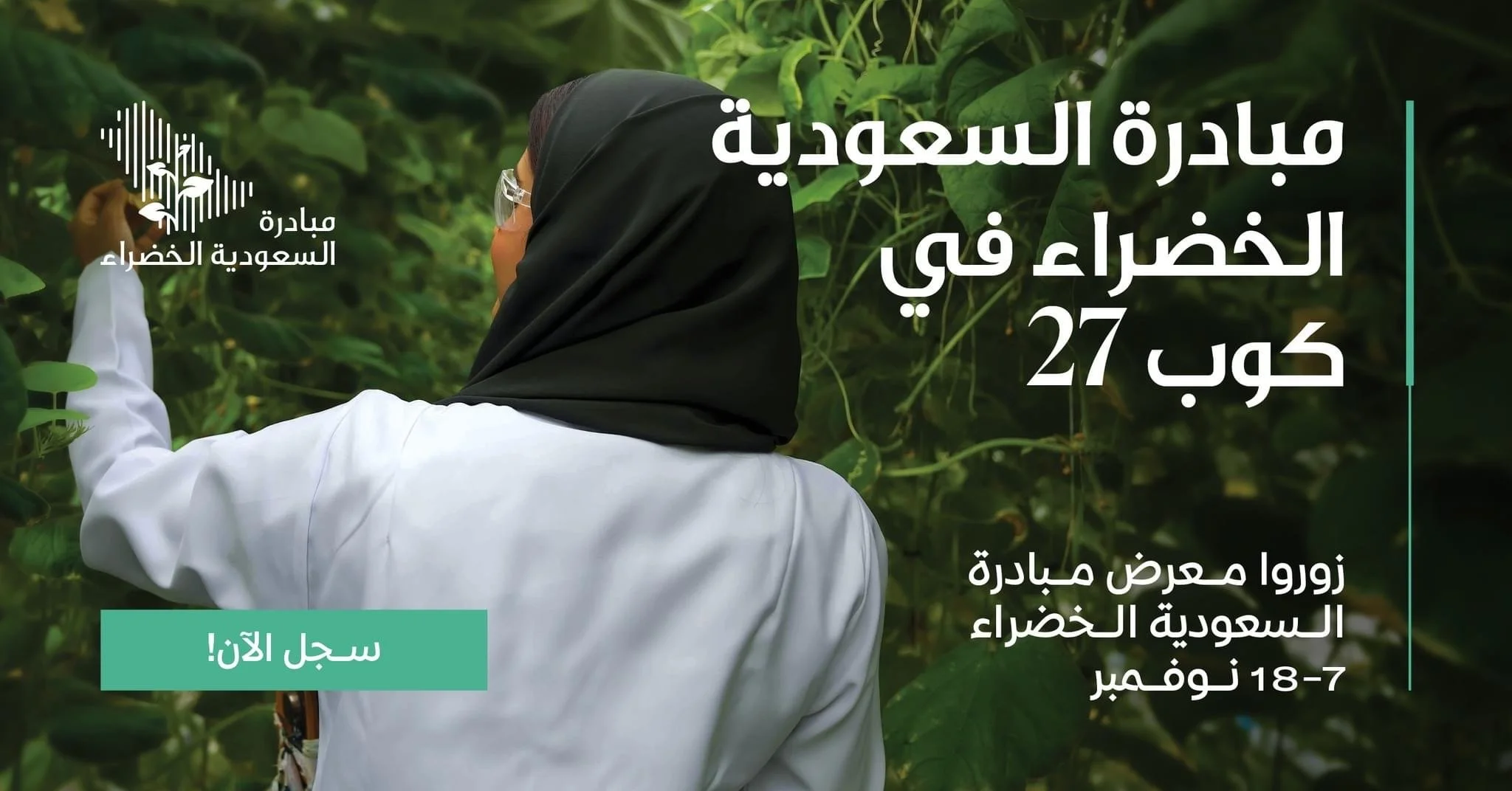 Una donna con hijab nero e camice bianco che raccoglie foglie in una serra di piante verdi.
