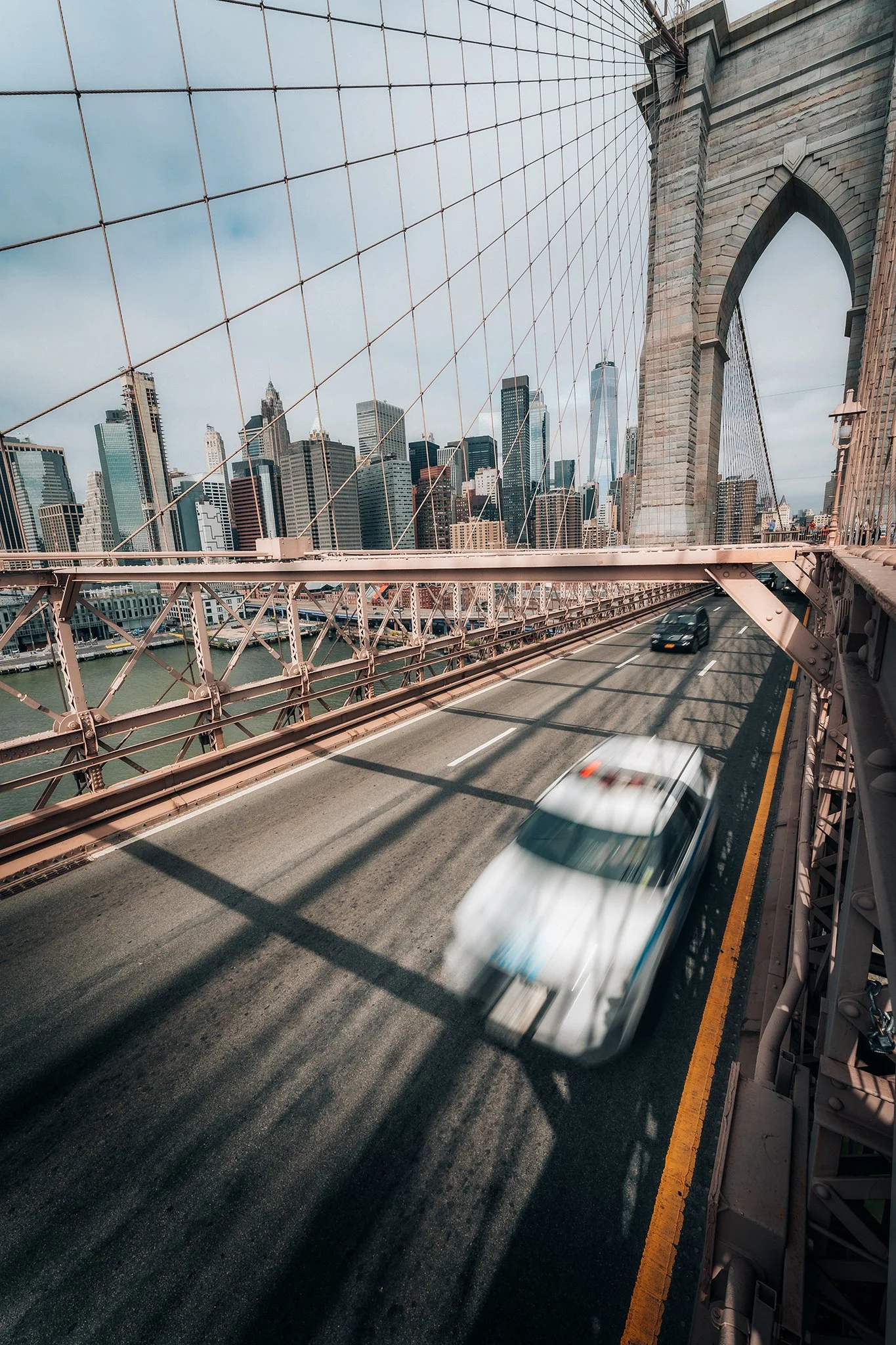 Vista del Ponte di Brooklyn a New York, con grattacieli dello skyline e traffico di veicoli sulla strada sottostante.