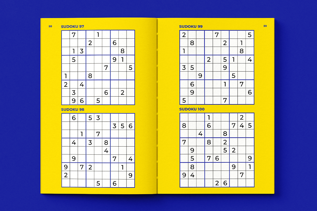 Open book showing four Sudoku puzzles on yellow pages