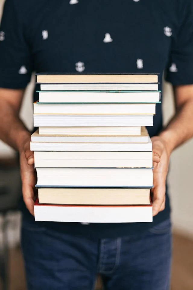person holding a stack of books