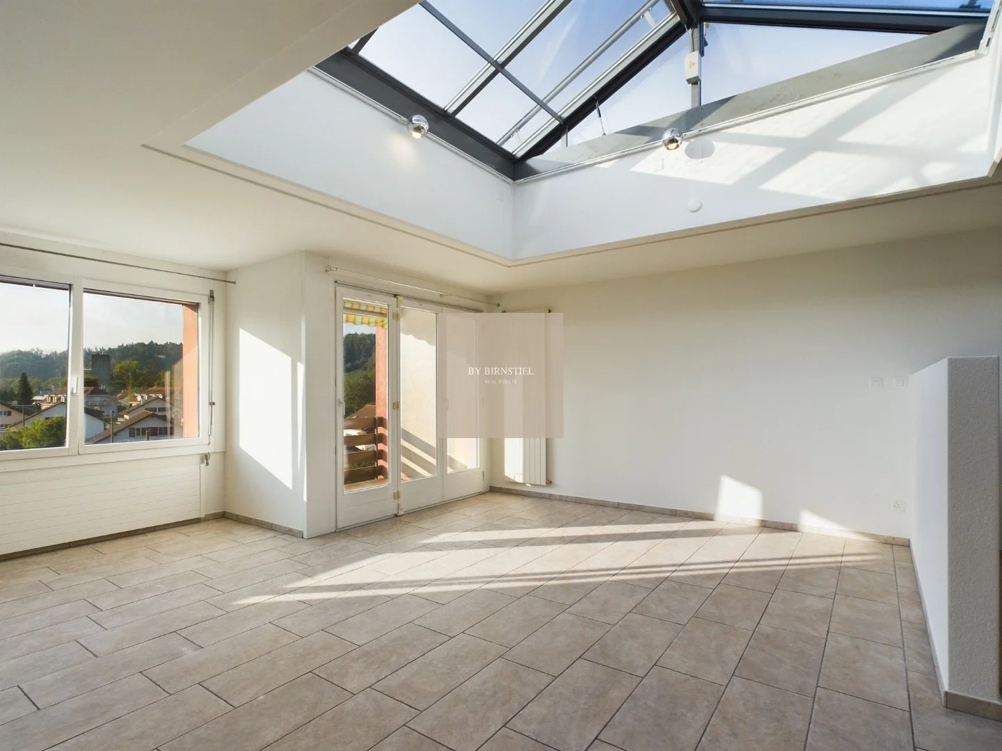 Grosszügiges, lichtdurchflutetes Wohnzimmer mit Blick auf die einzigartige Glaskuppel-Konstruktion.