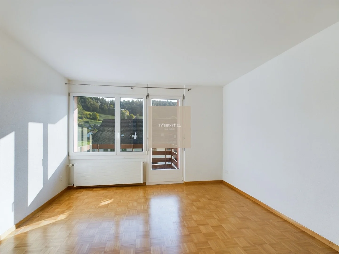 Helles Hauptschlafzimmer mit Parkettboden und direktem Zugang zu einem der Balkone. 