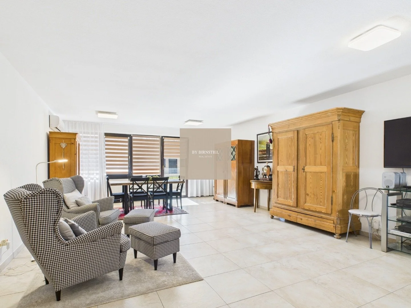 Helles Wohnzimmer mit Klimaanlage und direktem Balkonzugang.