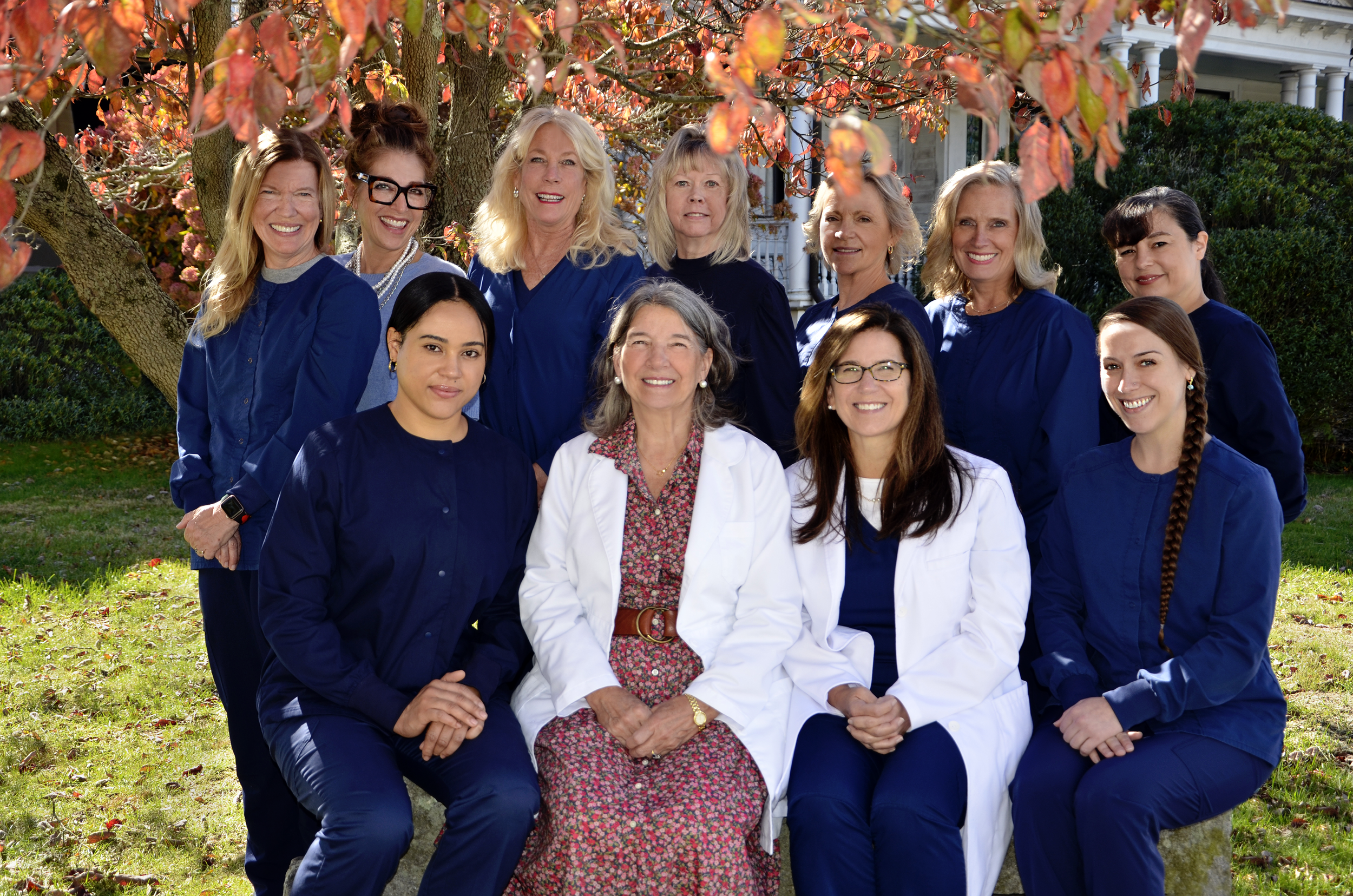 image of all of the staff including doctors seated outdoors in the fall sunshine
