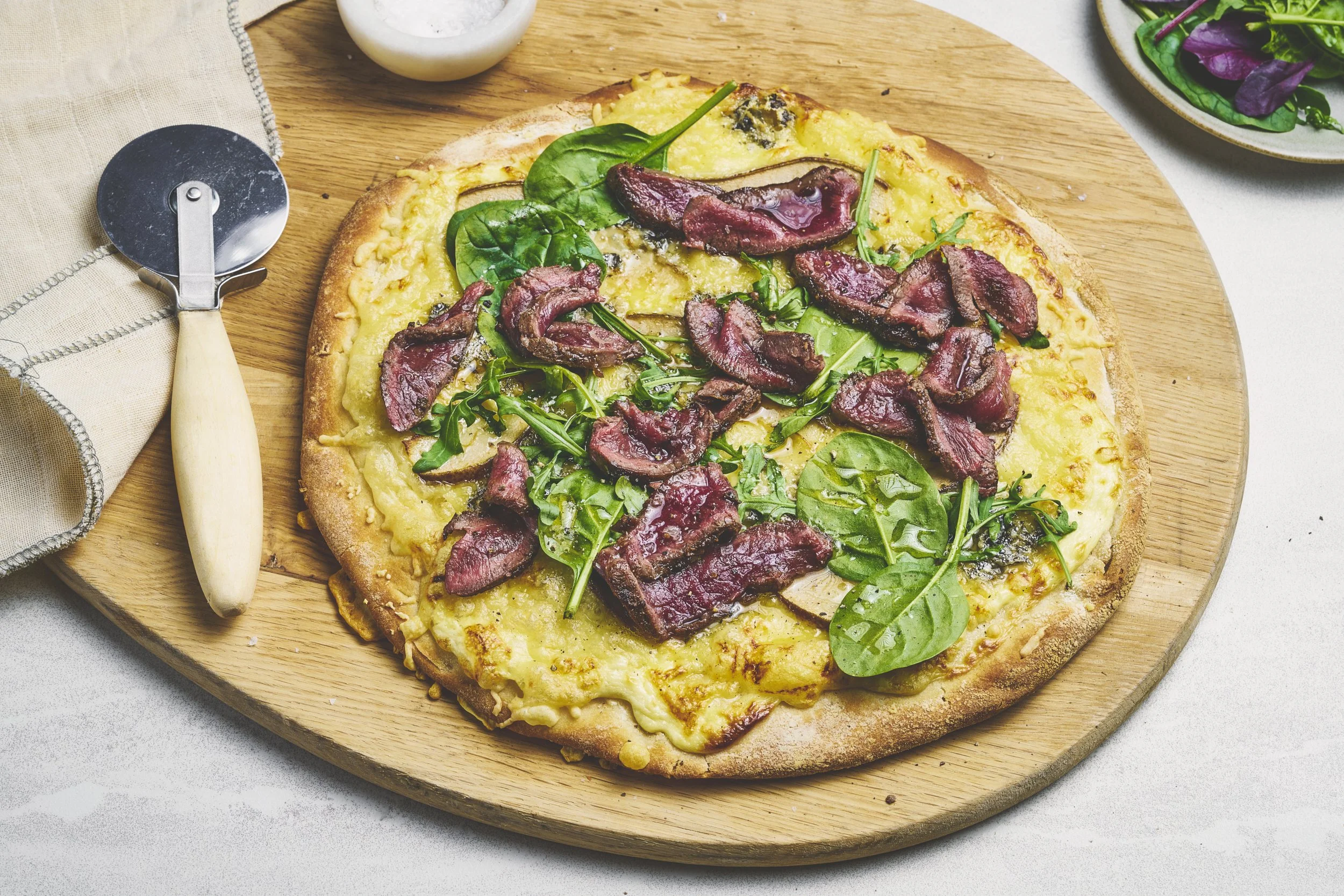 Hvit pizza med reinsdyr biff, pære og blåmuggost