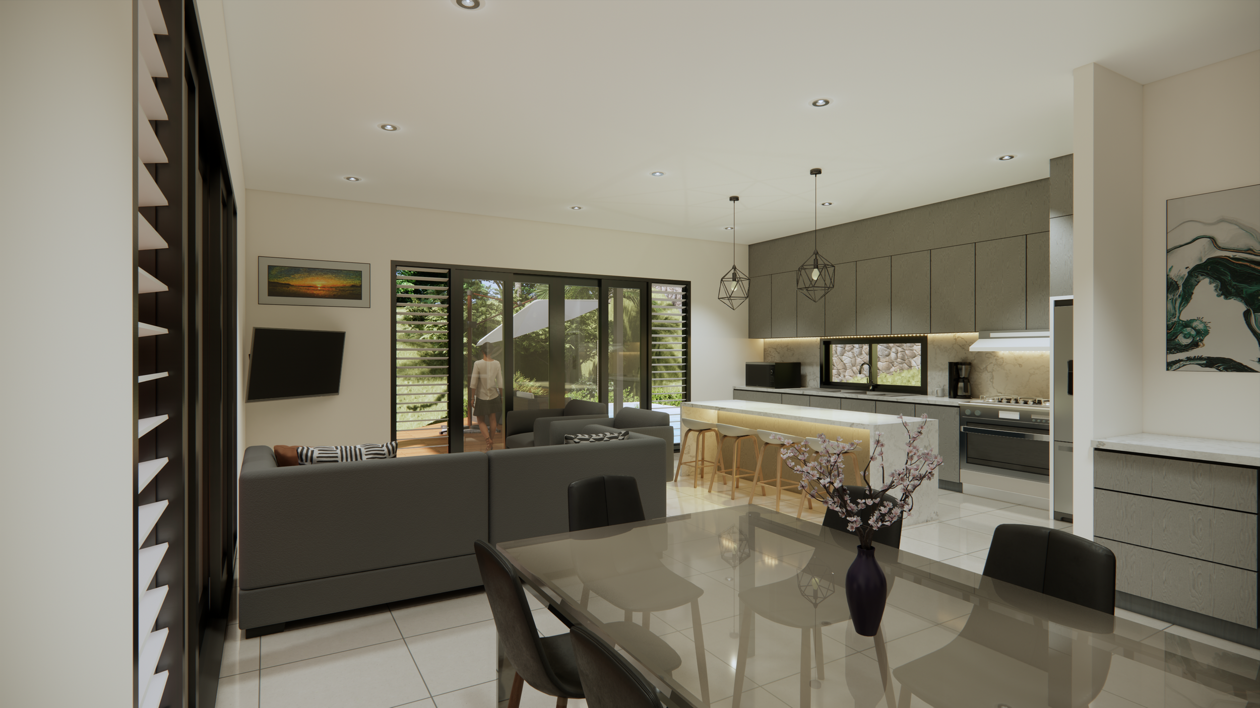 Modern open-concept living room and kitchen with sliding glass doors leading outside, gray sofas, a glass dining table with black chairs, and a vase of pink flowers.
