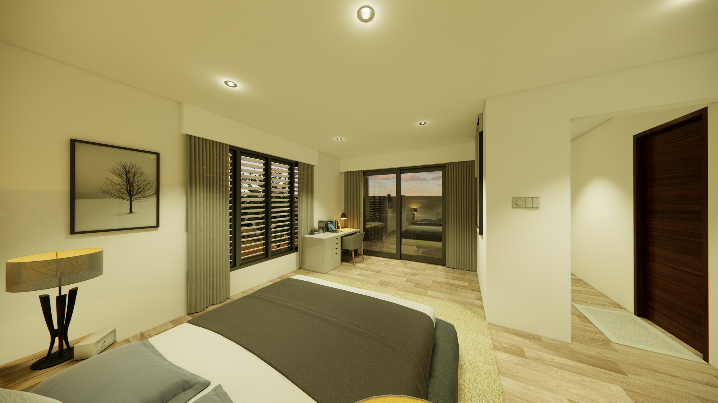 Interior of a modern bedroom with a bed, side table and lamp, framed picture of a tree, windows with blinds, a small desk with a chair, and a sliding glass door leading to a balcony during sunset.