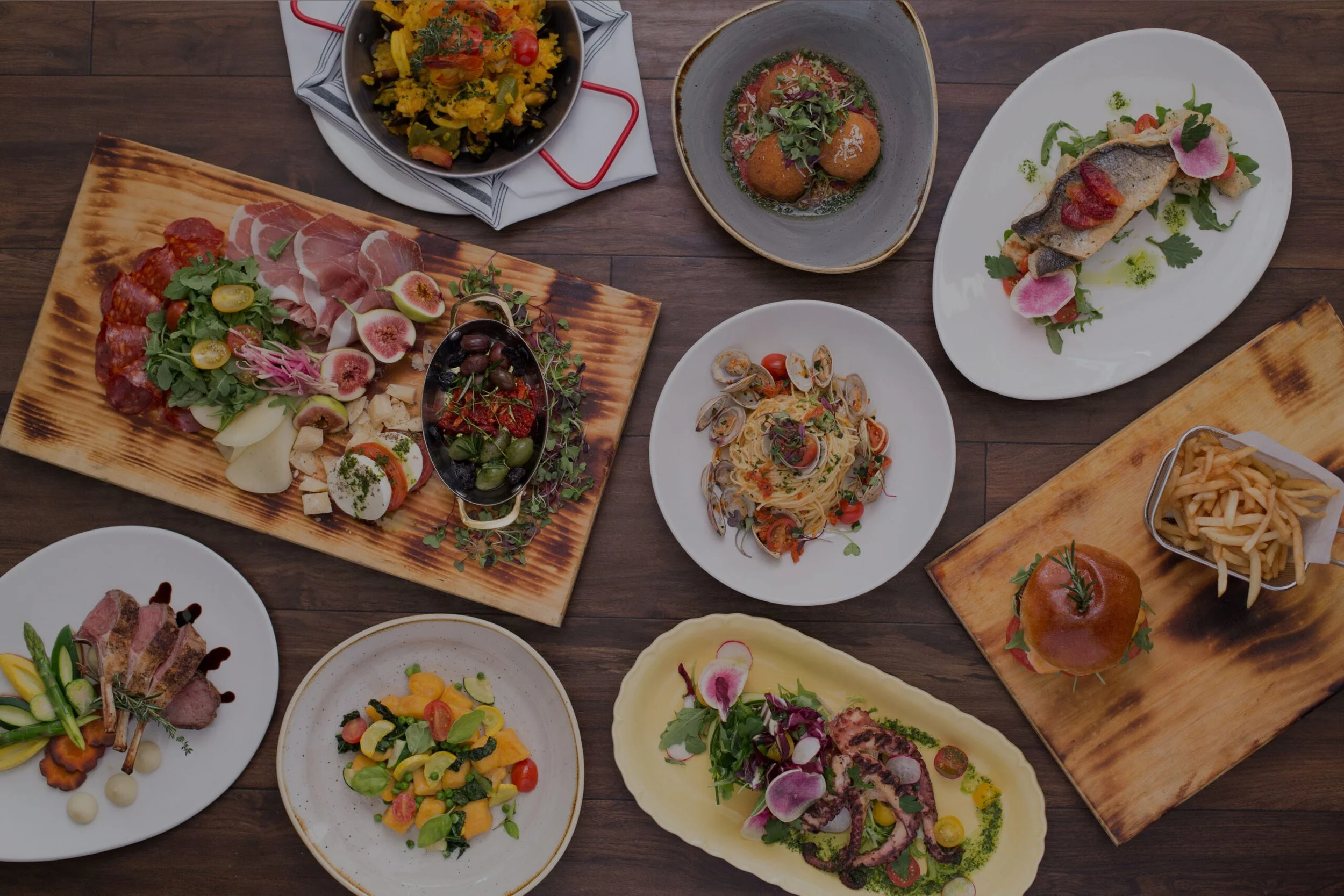 Assorted dishes including pasta, salad, roasted vegetables, and grilled meats, Octopus & Paella