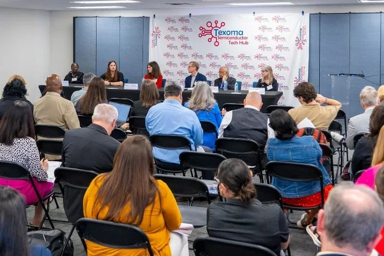 A panel of six people seated at a long table on a stage, facing an audience, at a conference titled "Texoma Semiconductor Tech Hub".
