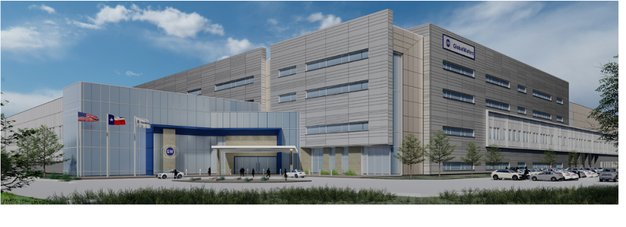Modern hospital building with flags, parking lot, and trees in front.