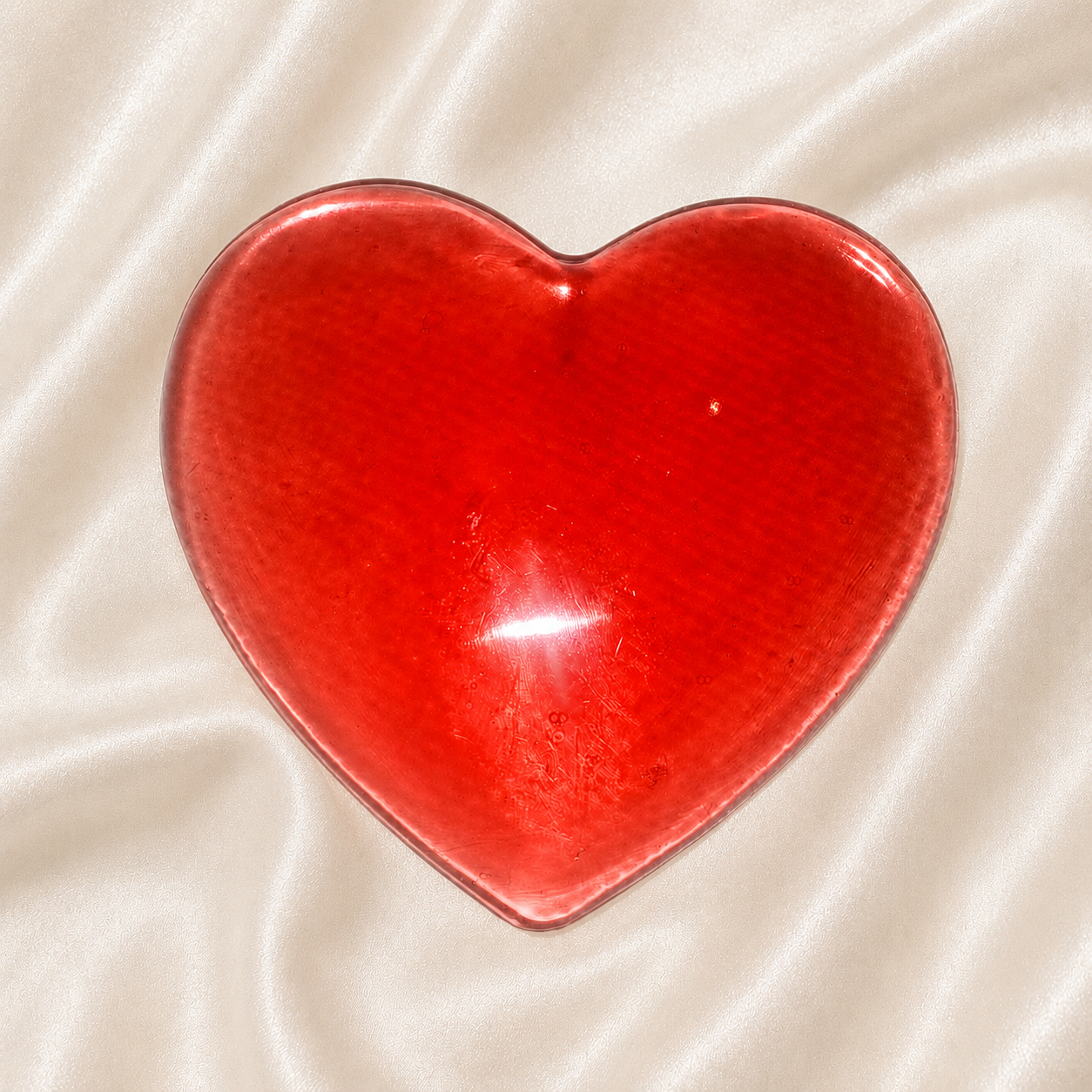 Generated image: Shiny heart on satin fabric.png